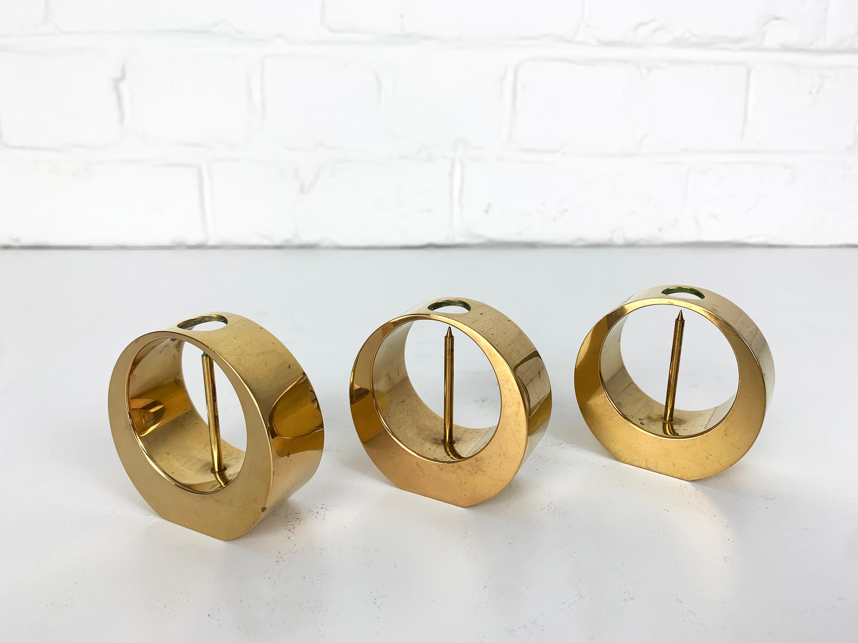 A set of three Mid-Century candle-sticks or candle-holders in solid brass. 

Created and made by Arthur Petterson, he signed his candleholders “Arthur Pe Kolbäck”.

The artist was born in 1919 in Kolbäck, Sweden, where he lived and worked all his