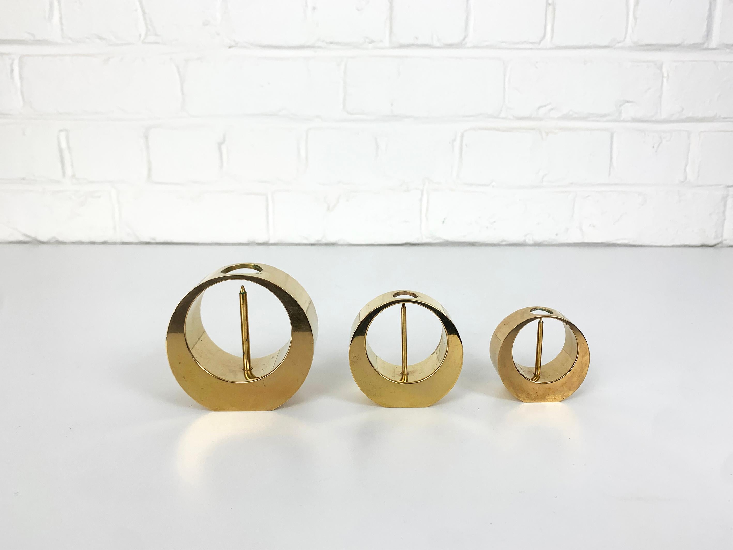 A set of three Mid-Century candle-sticks or candle-holders in solid brass. 

Created and made by Arthur Petterson, he signed his candleholders “Arthur Pe Kolbäck”.

The artist was born in 1919 in Kolbäck, Sweden, where he lived and worked all his