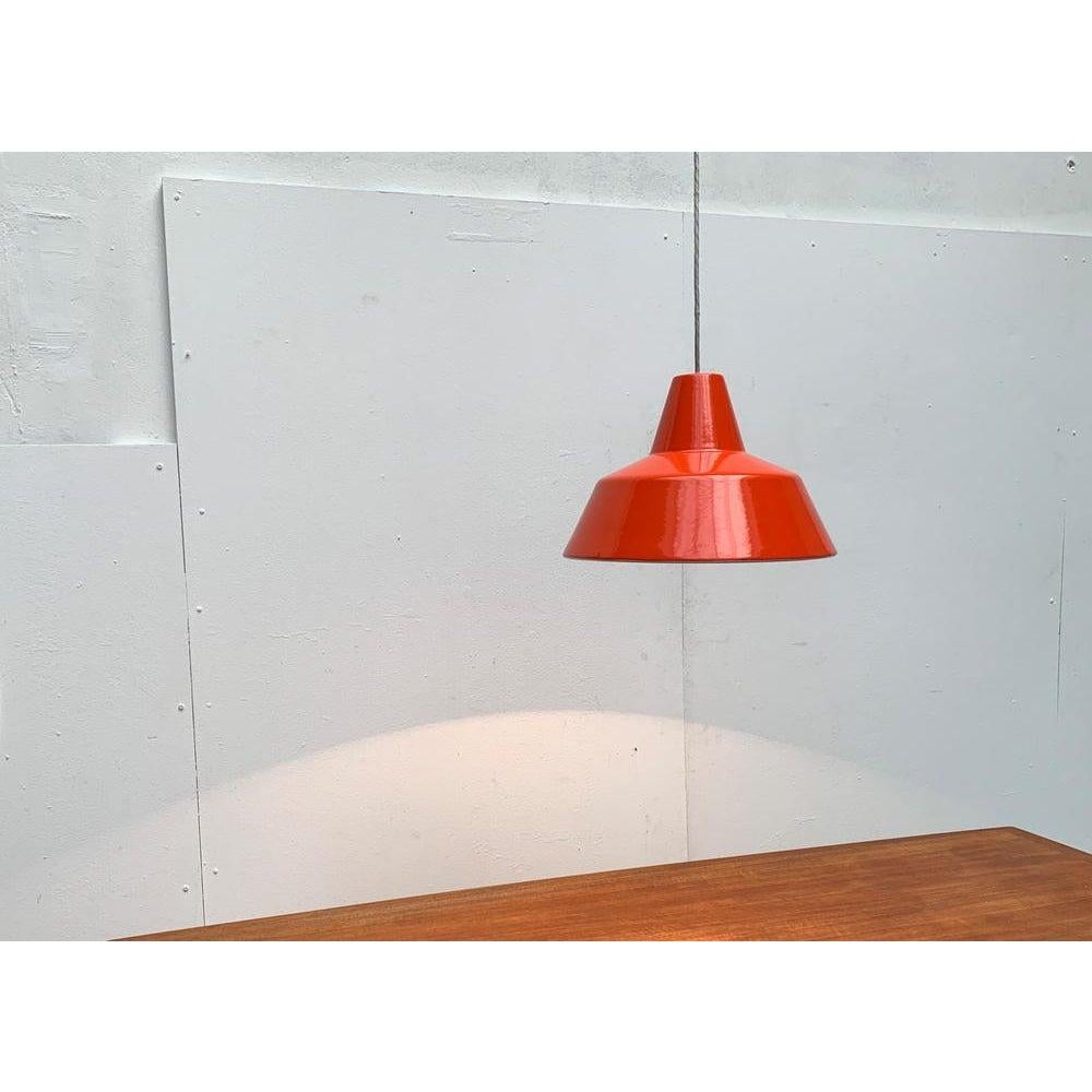 Semplice lampada a sospensione smaltata in arancione del produttore danese Louis Poulsen. Conosciuta anche come Emaille-Amatur o Arbejd spendula.

Un design archetipico. Pendolo funzionale nella classica forma di una lampada industriale o da