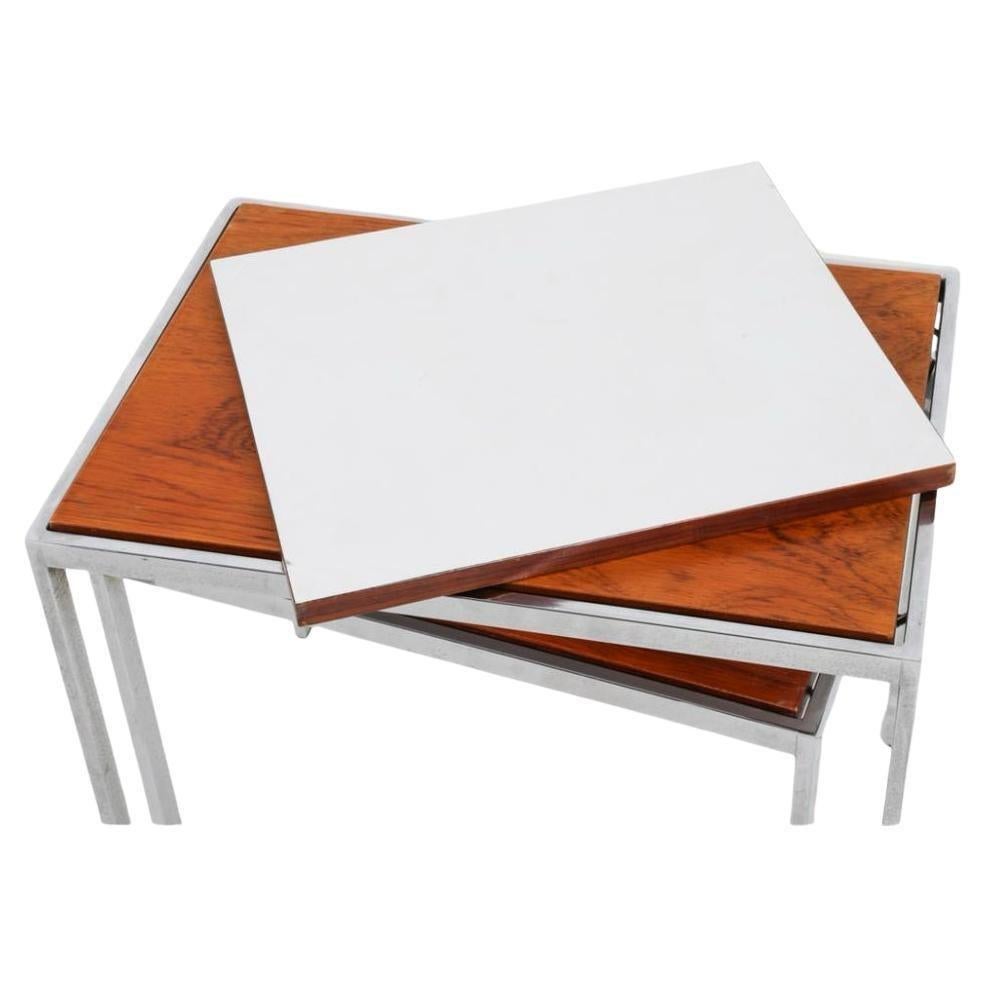 Set of 3 Mid-Century Danish Modern rosewood and chrome nesting tables. They all nest stacking downward. 3 tables total. The dimensions are for all the tables nested into one. You can flip the table tops to white laminate on the underside. Good