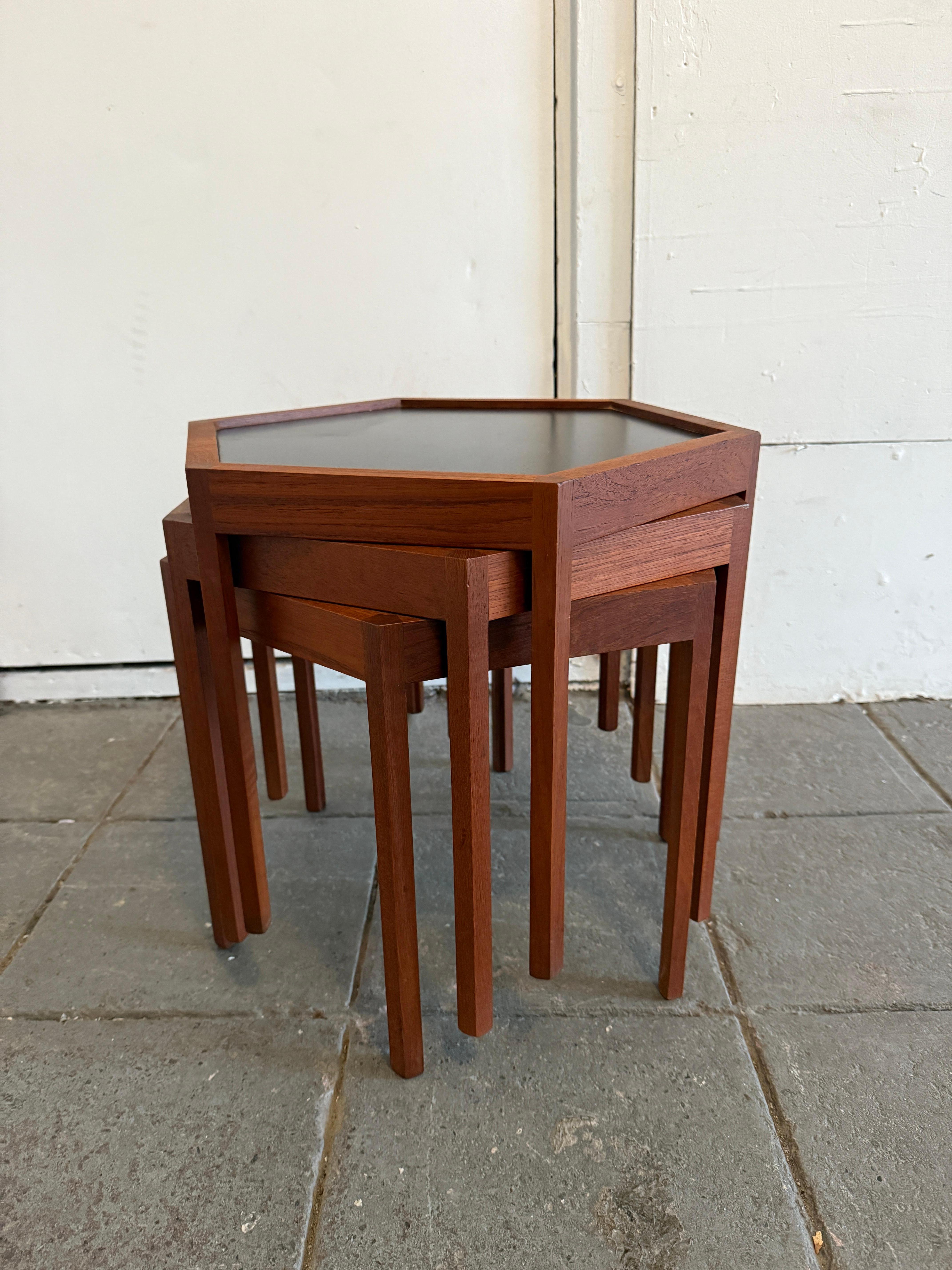 Set of (3) Mid century Danish modern teak hexagon stacking tables by Hans C. Andersen. Solid teak with black Formica tops. Beautiful woodworking and design. Very fun cool set. Great vintage condition. Labeled Made in Denmark by Arlex.

(1) Set of 3