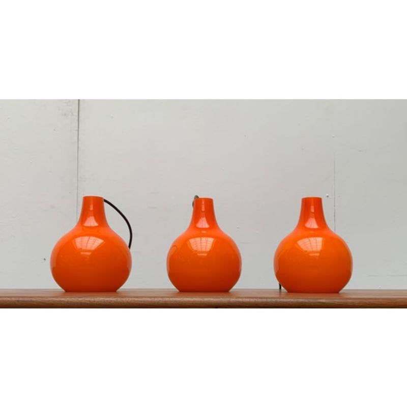 Pendenti in vetro della metà del secolo scorso del rinomato produttore Putzler.

Il corpo della lampada, realizzato in vetro arancione, ha un'elegante forma a goccia. Nella parte inferiore è aperta ed emette luce diretta. Allo stesso tempo, il