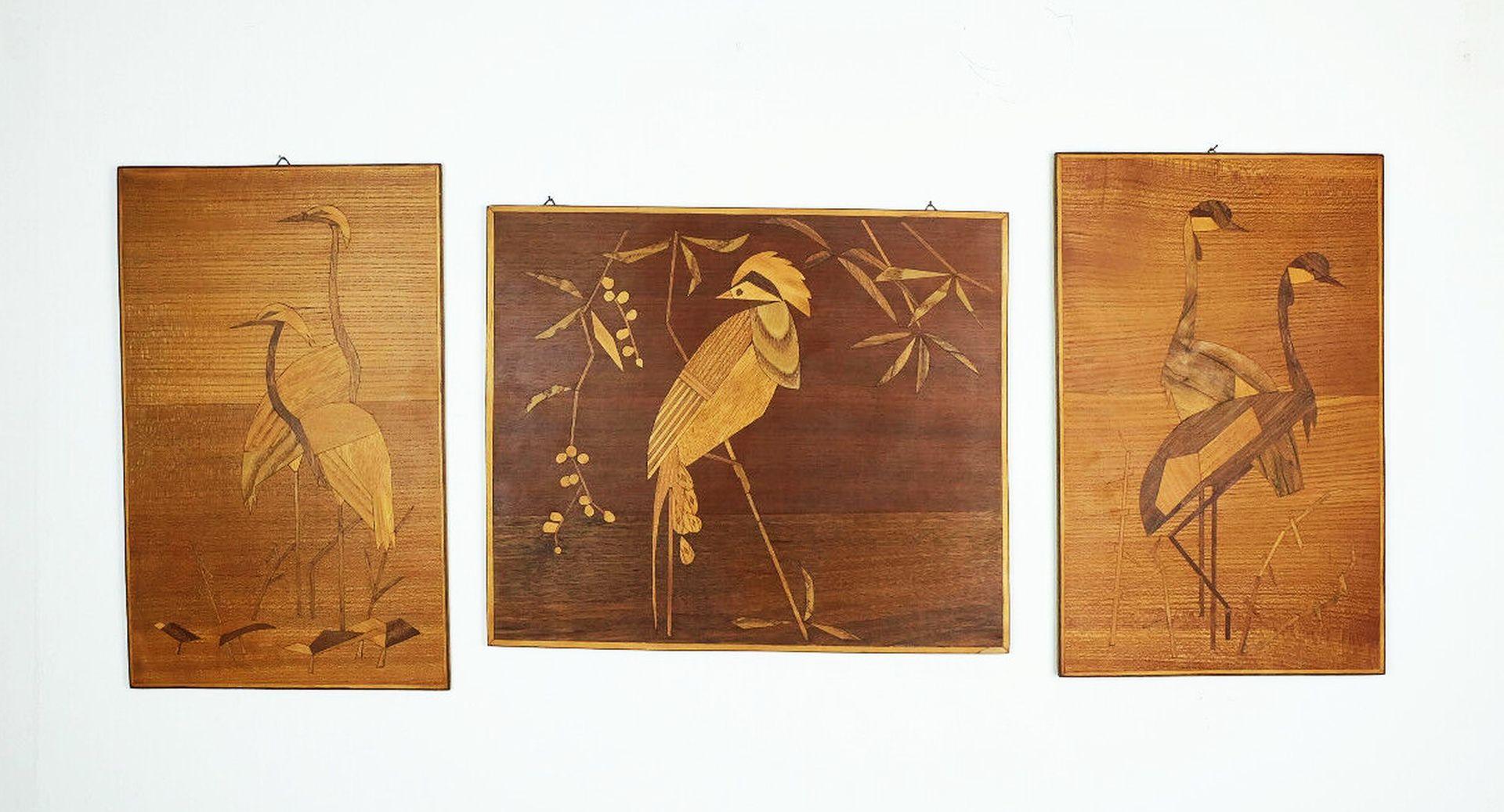Set of three perfectly crafted intarsia pictures from the 1950s to 60s. Various wood veneers on chipboard, the surfaces are oiled. Very nice stylized depiction of birds.

A typical mid century artwork and a great addition to any modernist interior.