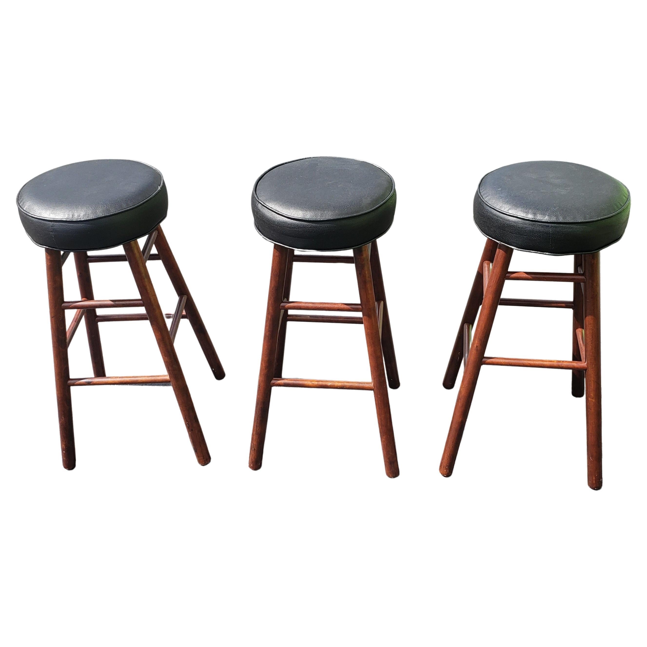 Set of 3 Mid-Century Maple and PU leather seat bar stools measuring 14 inches in diameter seats, 16.5 inches wide and 16.5 inches at the base and stand 30
