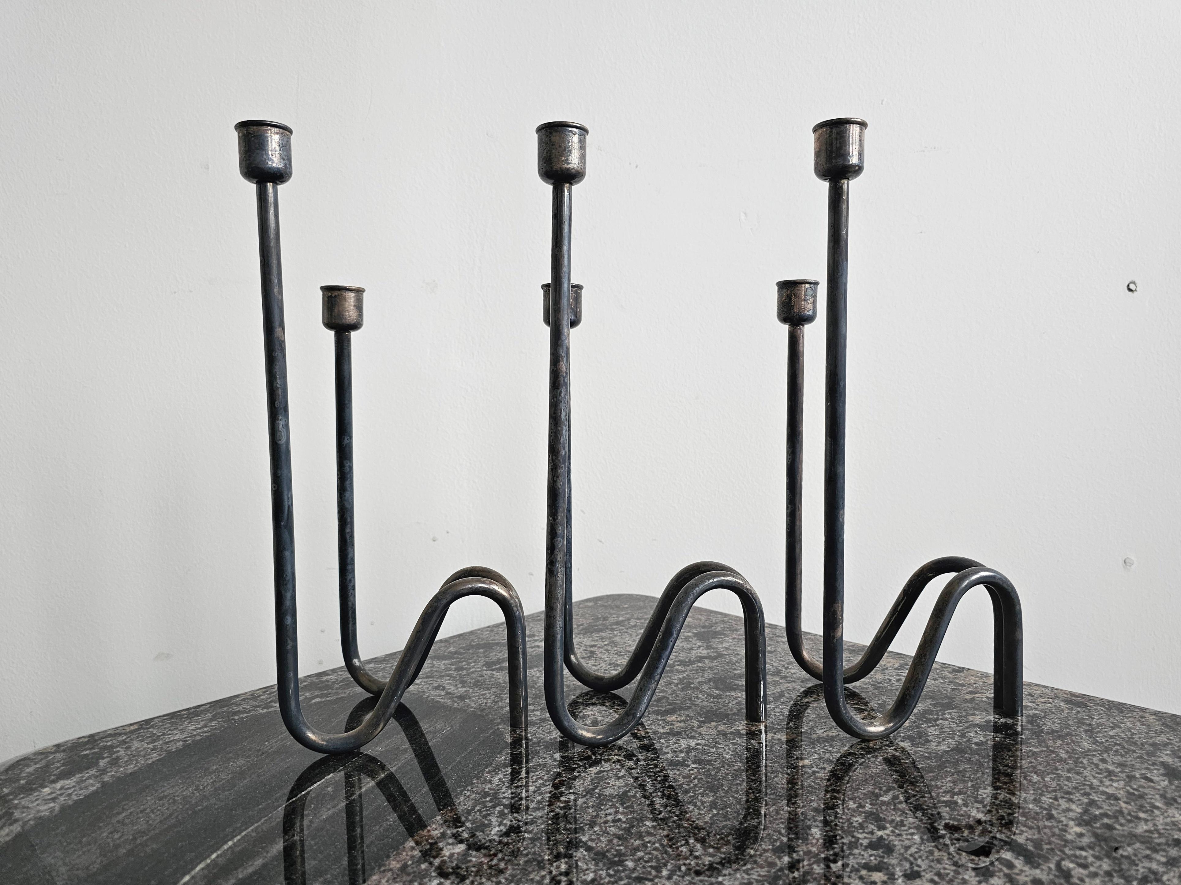 In this listing you will find a set of 3 minimalist silver-plated candlestick holders designed by a renowned Italian designer and silversmith Lino Sabattini. Minimalist and elegant design allows you to set them up in various positions, together or