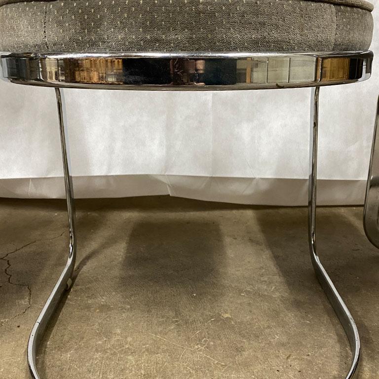 Set of three upholstered chrome chairs. Each chair features a rounded upholstered back that slopes down to the upholstered seat. The square seat which has a rounded back, complimenting the back of the chairs. A solid cantilever base supports these