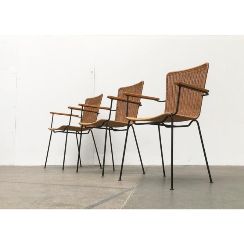 Un design che convince per la sua semplice eleganza. La struttura della sedia in filigrana è composta da barre rotonde nere. Le gambe si chiudono in basso con semplici piastre. I braccioli sono realizzati in legno massiccio e avvitati alla