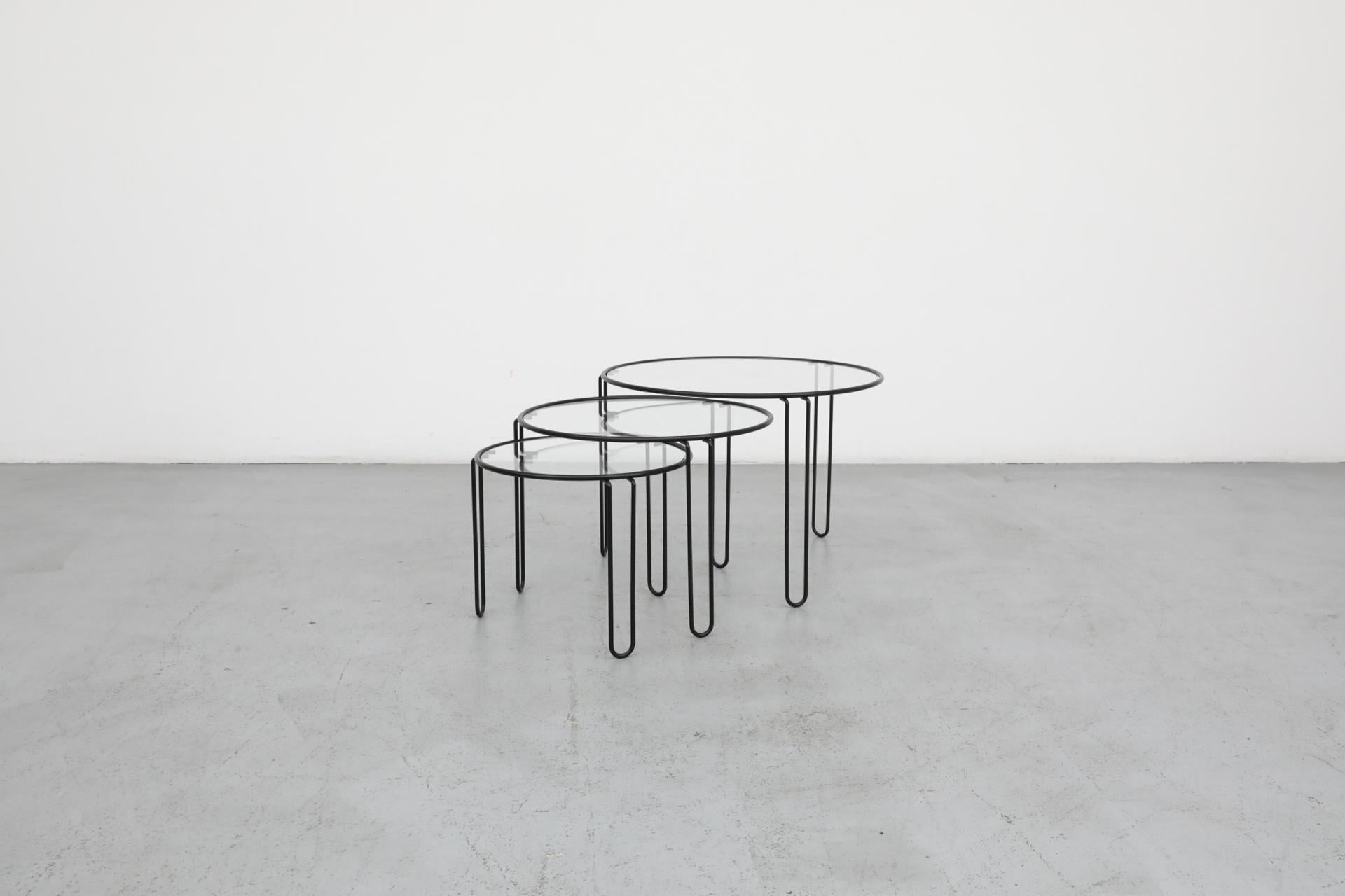 Mid-Century MOD set of 3 black enameled metal minimalist circular wire nesting tables. Each table has three rounded 