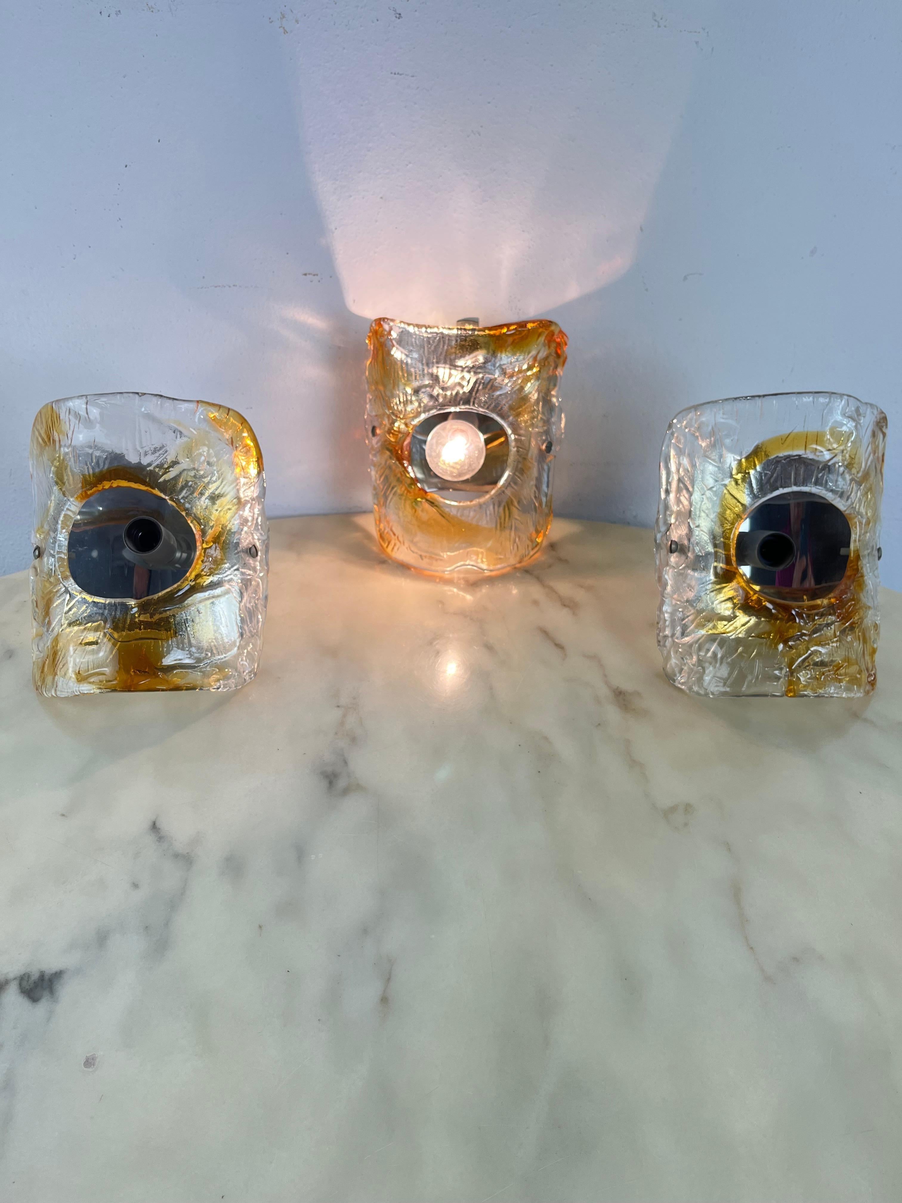 Set of 3 Mid-Century Murano Glass Wall Lamps Attributed to Mazzega 1960s
Metal structure, E14 lamps. Intact and functional, good condition.

We guarantee adequate packaging and will ship via DHL, insuring the contents against any breakage or loss of
