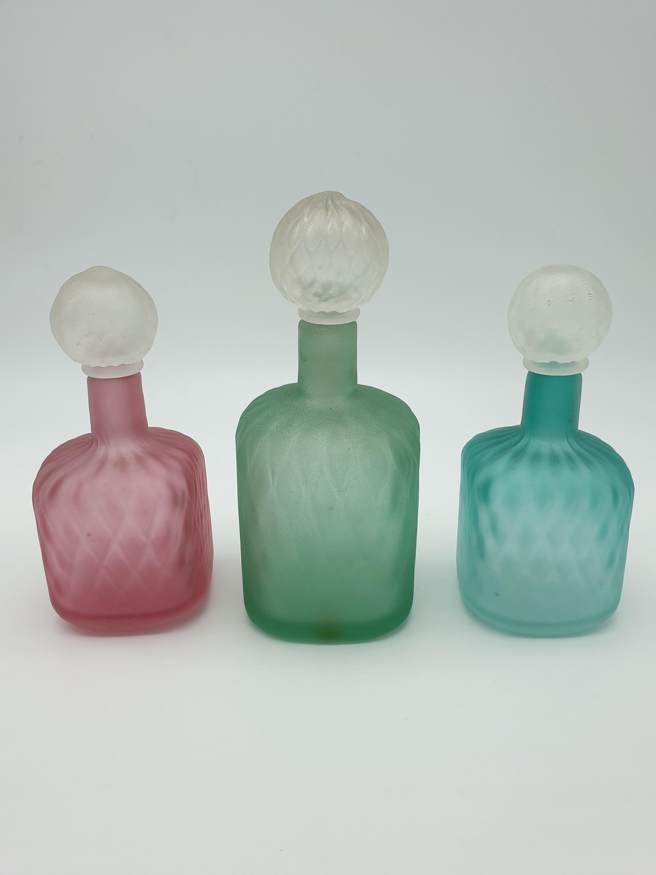 Set of three modern Murano glass jugs, completely hand-made and blown by Gino Cenedese e Figlio glass factory in the mid-1980s. This colorful set is made of three square cross-section jugs in different sizes: a larger green jug and two medium sized
