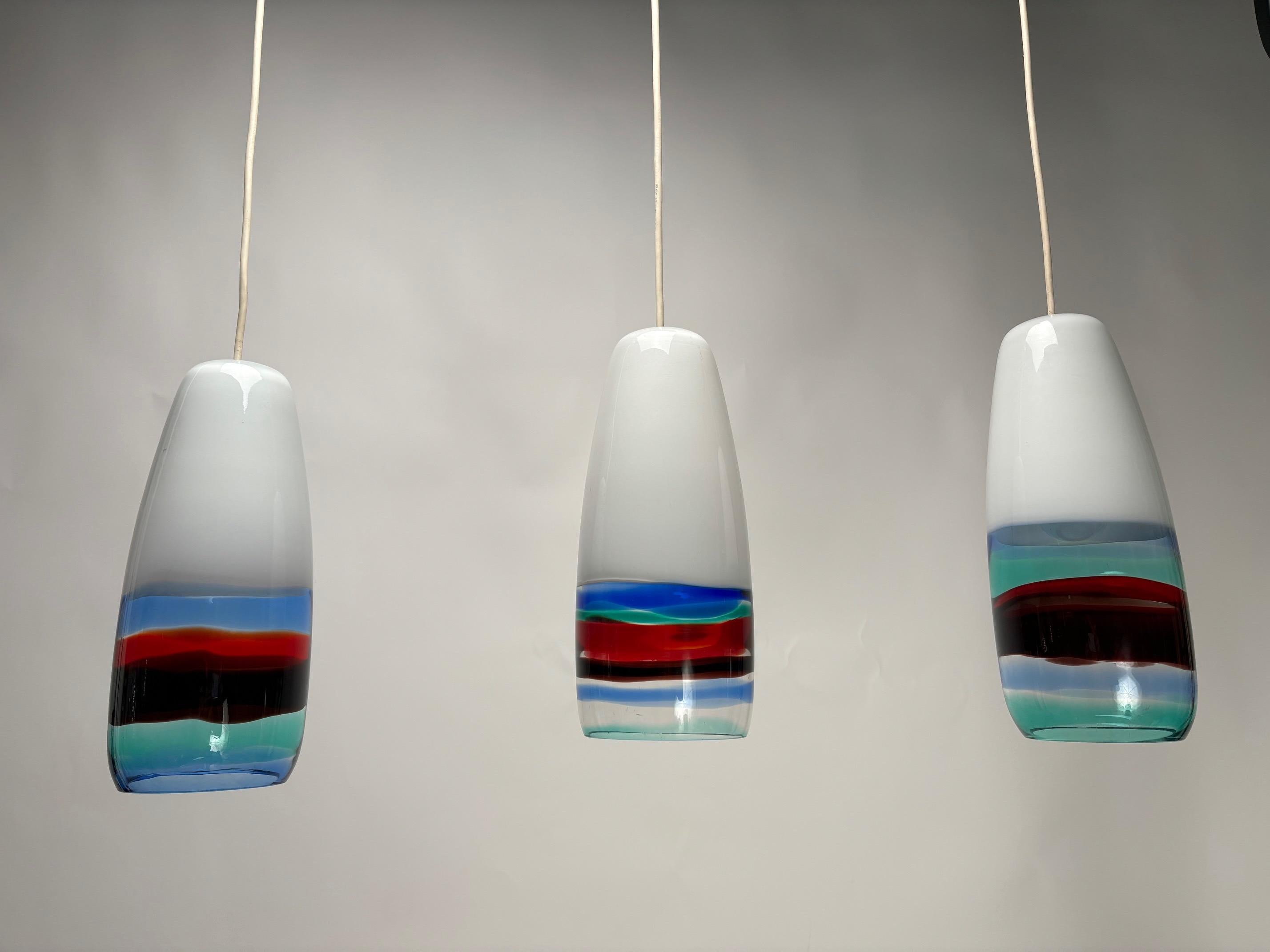 Raro e straordinario set di 3 pendenti Model 4035 multicolore soffiati a mano, disegnati da Massimo Vignelli all'inizio della sua impressionante carriera nel mondo del design e prodotti dallo specialista del vetro di Murano Venini. Il modello è noto