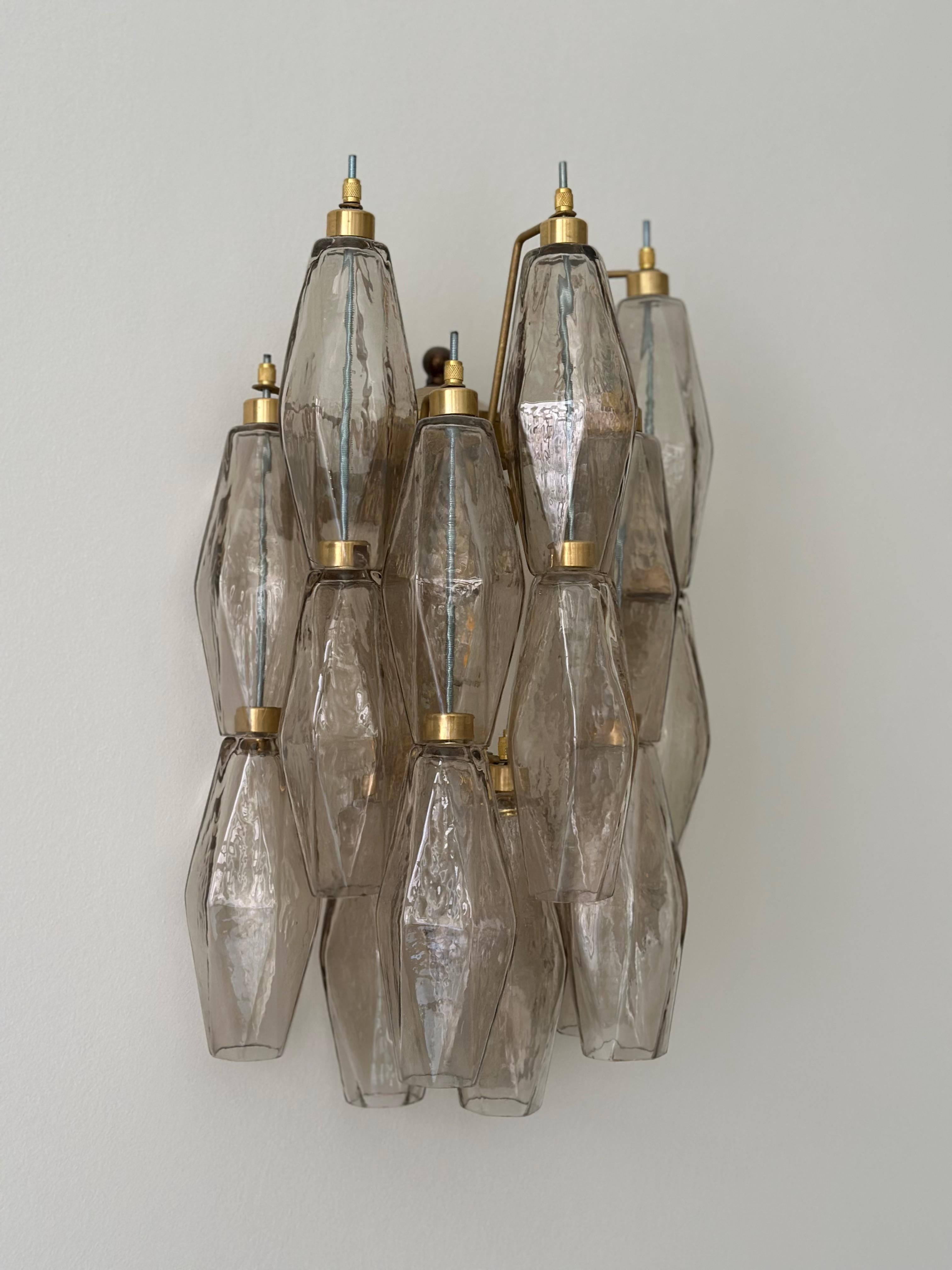 Ensemble de trois appliques Murano composées de 17 prismes de cristal faits à la main en verre de Murano de couleur sable. Structure de la lampe en métal avec des ferrures peintes dans un ton brun clair, bronzé. Verre du district italien de Murano.