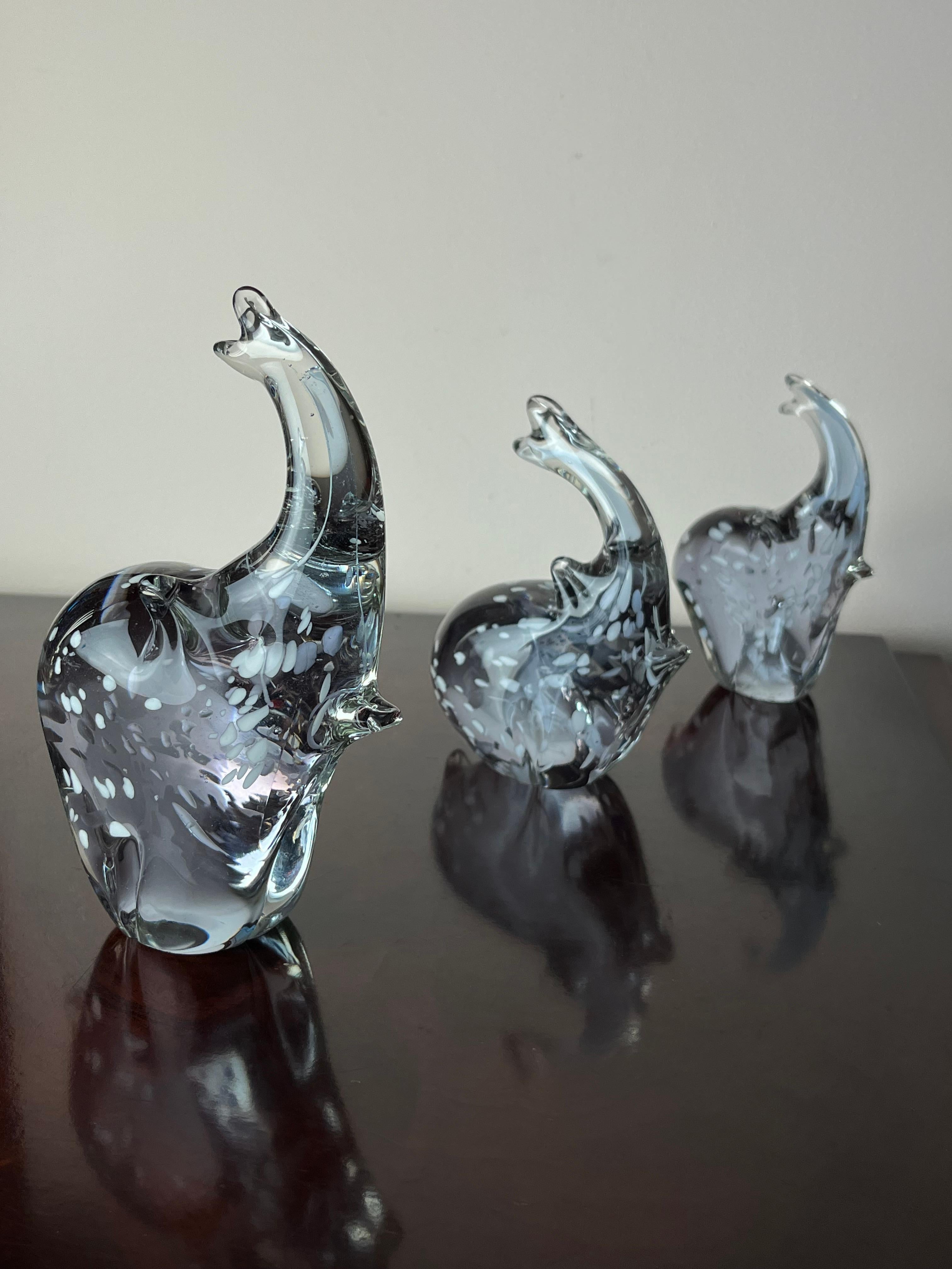 Set di 3 elefanti in vetro di Murano, Italia, anni '70. Il più grande, intatto, è alto 18 cm, largo 13 cm e profondo 6 cm; il medio, intatto, è alto 15 cm, largo 11 cm e profondo 4,5 cm; il piccolo ha una piccola rottura, appena visibile. È alto 13