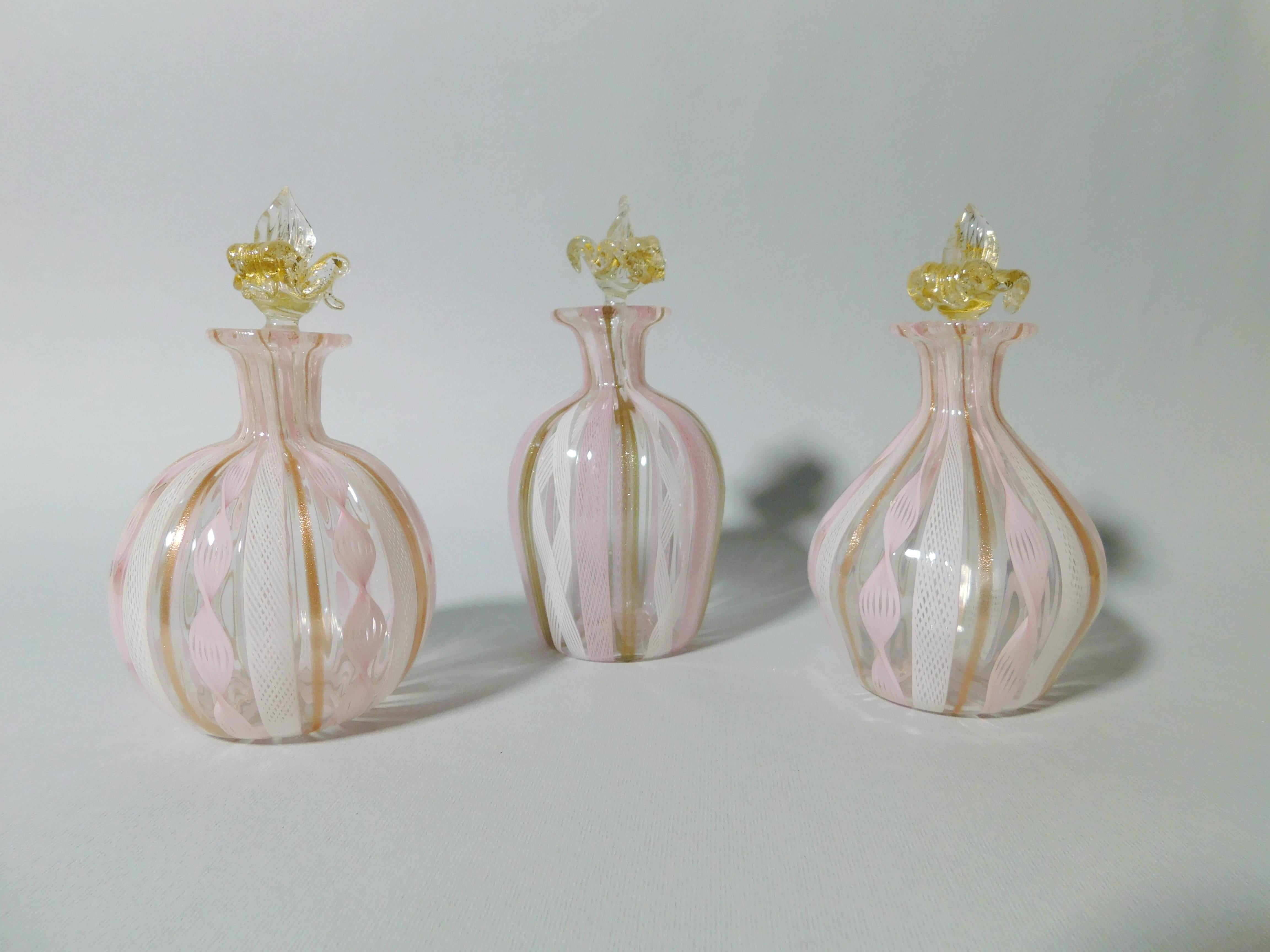 Set di 3 flaconi di profumo in vetro di Murano con filigrana bianca e rosa, realizzati in Italia negli anni '60 circa 
Misure: altezza 4/5 pollici, diametro 2/3 pollici
1 set disponibile in magazzino in Italia
Riferimento ordine: FABIOLTD