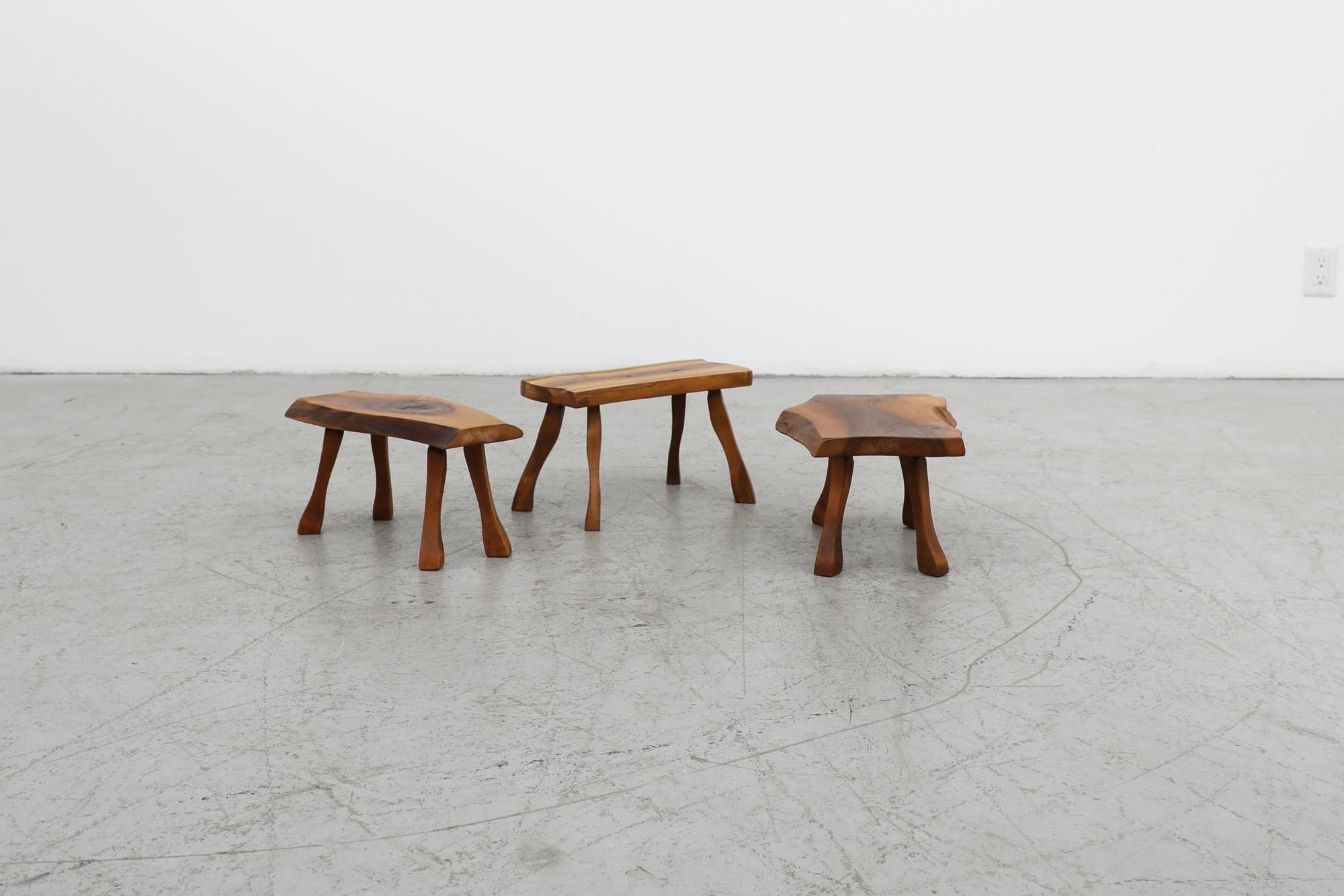 Gorgeous set of 3 George Nakashima style live edge stools or mini tables. Each piece has an original and unique live edge with beautifully carved legs that echo the natural curves of the live edge. In original condition with visible wear consistent