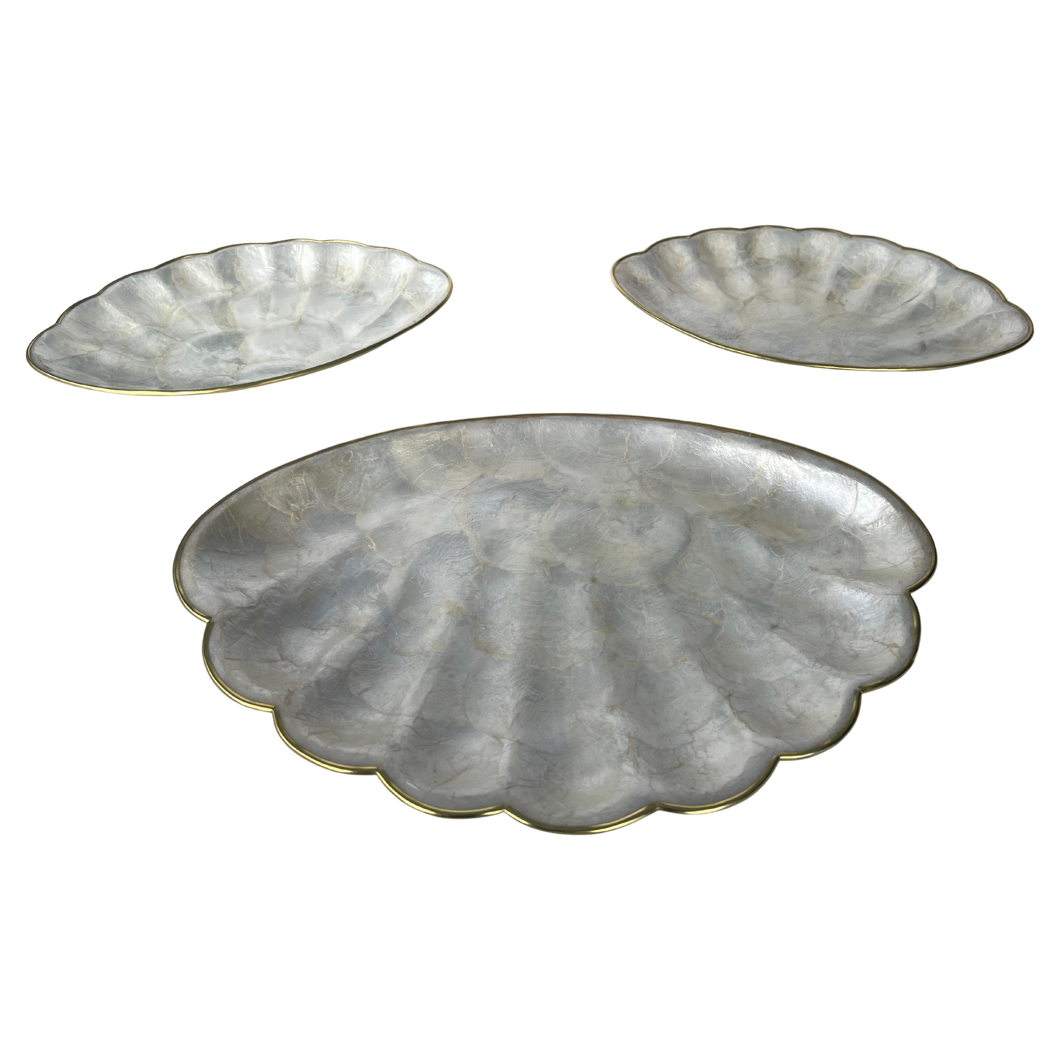 Set aus 3 muschelförmigen Vorspeisentabletts mit Messingrändern und Korkböden. In sehr gutem Zustand. Handgefertigt auf den Phillipinischen Inseln.
Das Dreier-Set enthält ein Tablett mit den Maßen 12,5