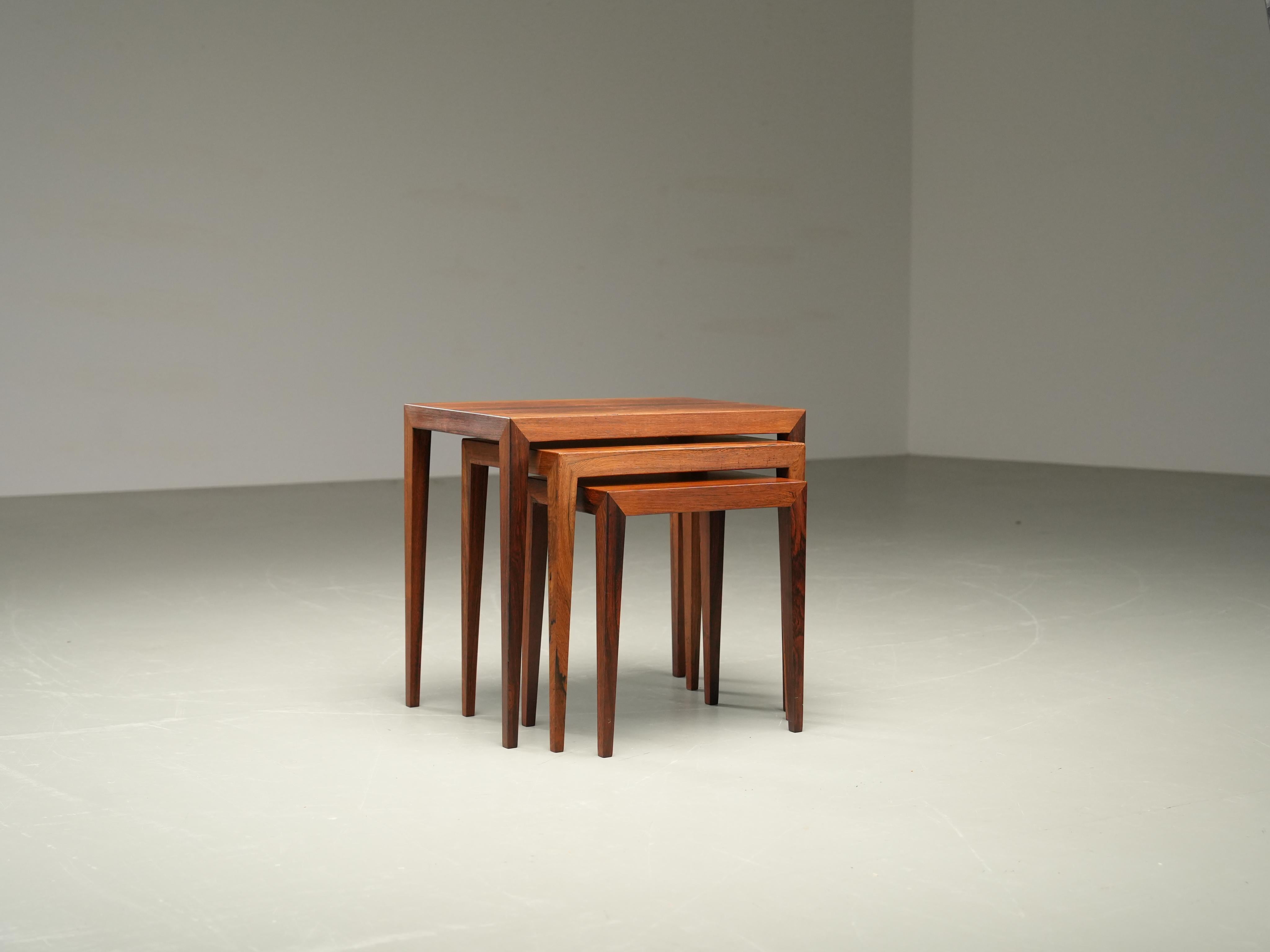 Conjunto de tres mesas nido diseñadas por Severin Hansen y fabricadas por Haslev Møbelsnedkeri en Dinamarca en la década de 1960. De teca ricamente veteada, con un profundo tono cálido y elegantes dibujos naturales. La construcción de esquinas