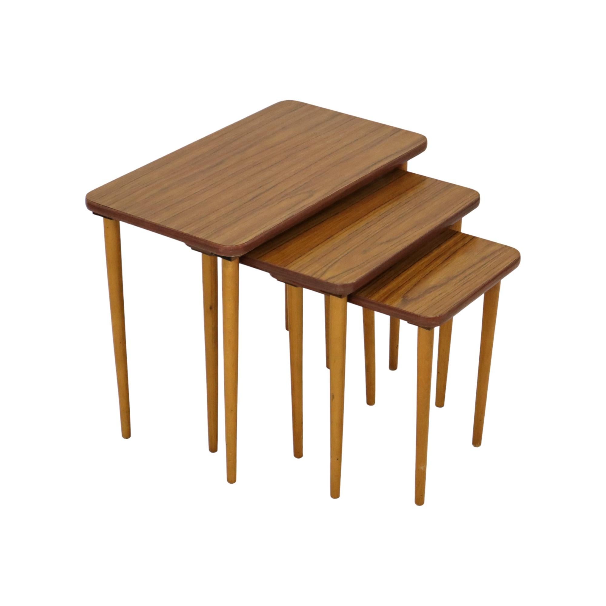 Precioso conjunto de 3 mesas nido de fórmica con dibujo de nogal y patas cónicas de haya maciza, diseño vintage de los años 50.

Mimiset cualitativo y elegante, encaja perfectamente en un interior vintage o moderno, los tableros son muy fáciles de