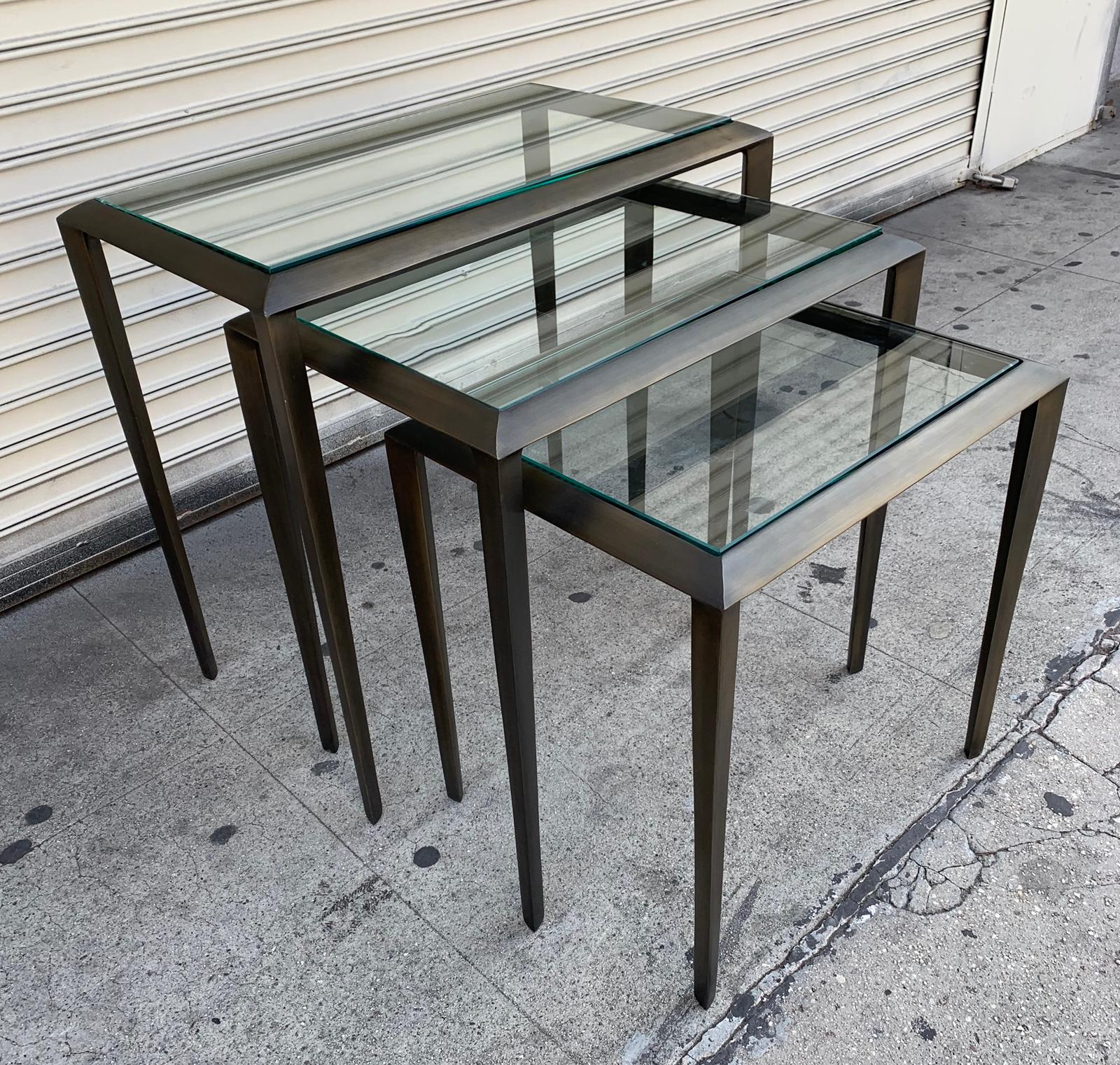 Beautiful set of nesting tables in antique brass with glass tables, the frames have a triangular shape, the tables have a beautiful patina and are in excellent condition.
Measurements:
30 wide x 18” deep x 28” high
26” wide x 18” deep x 25”