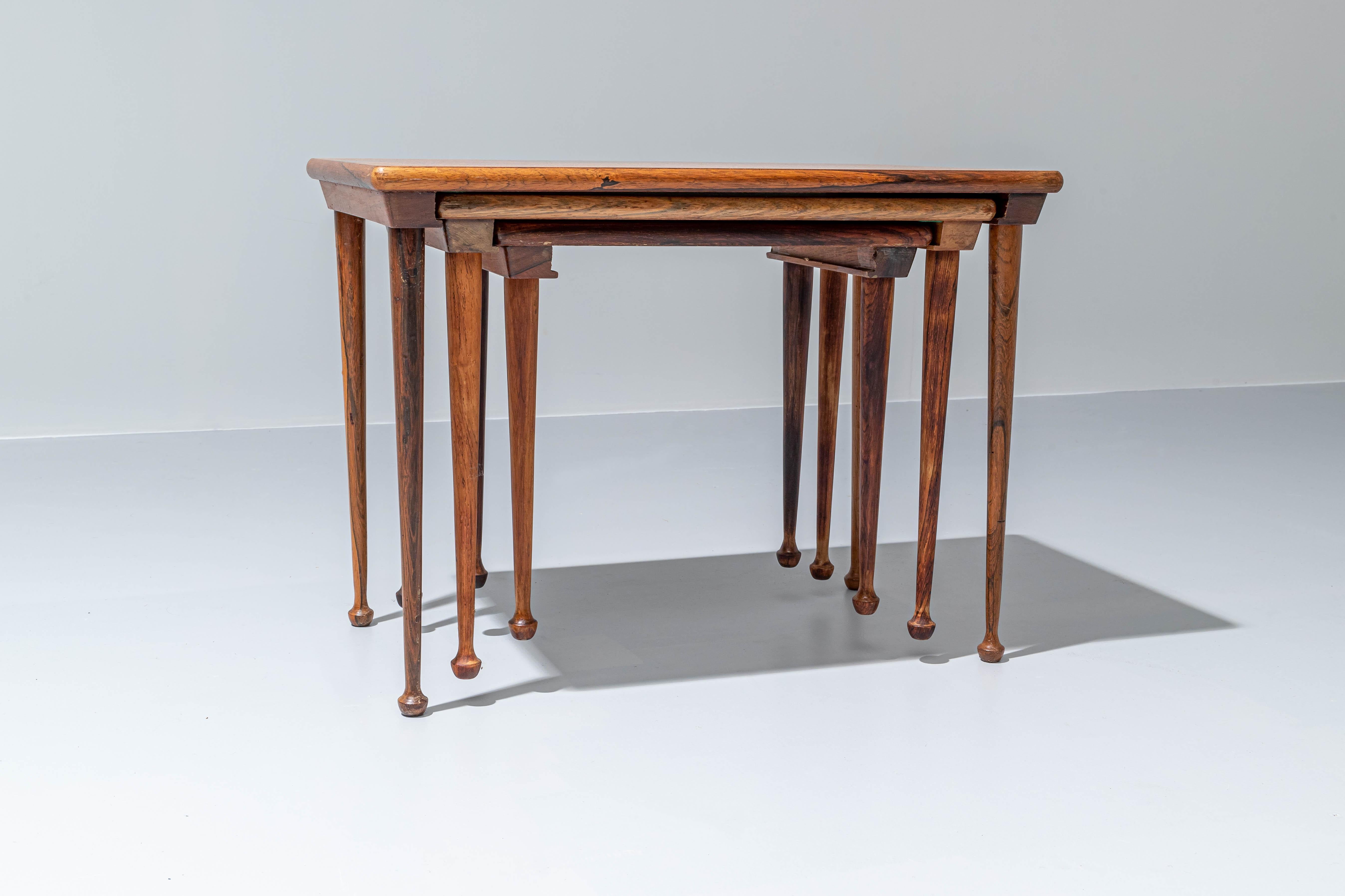 Set of 3 practical and beautiful nesting tables in rosewood. What stands out are the elegant legs with interesting flames in the rosewood and stubby feet. Rosewood is a very strong high-quality hardwood that serves very well for wood-turning and