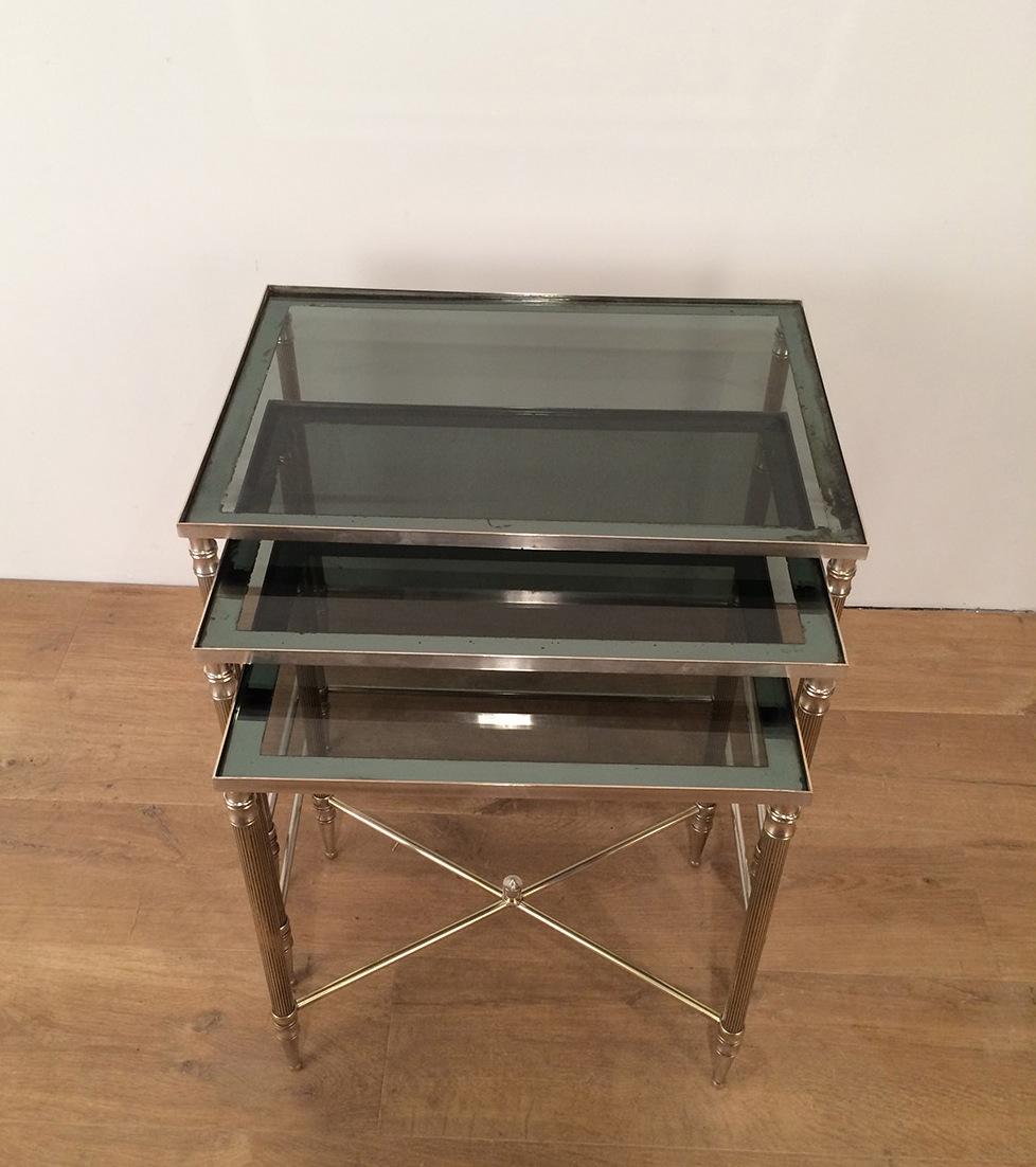 This nice set of 3 neoclassical style nesting tables or stacking tables are made of silver plated with blueish glass tops. This is a french work, circa 1960.