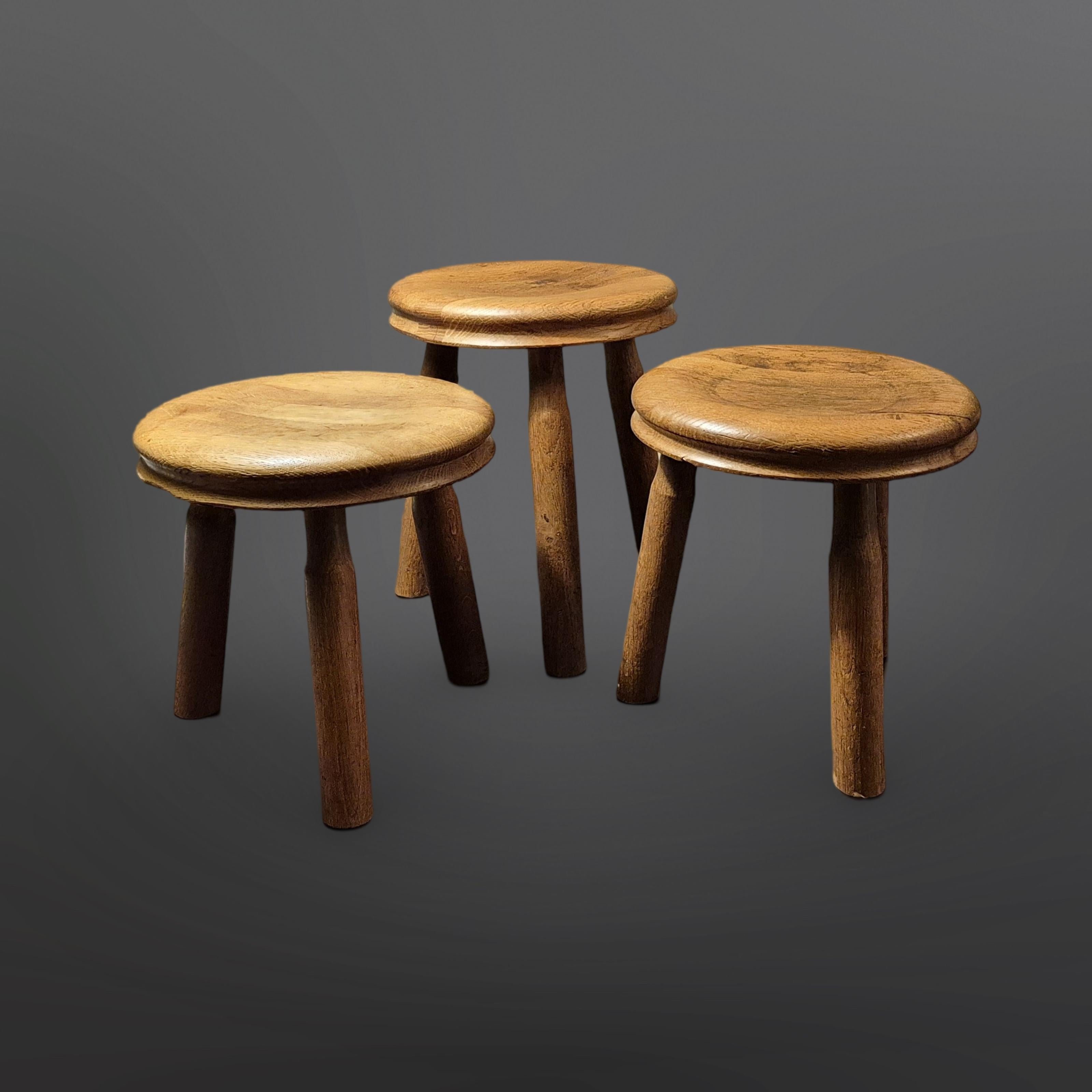 Juego de 3 taburetes trípode. Piezas originales a la manera de Charlotte Perriand y Pierre Chapo. Están hechos de roble macizo. Con los asientos cóncavos y la línea rebajada alrededor del asiento, destacan sobre la mayoría de los taburetes de