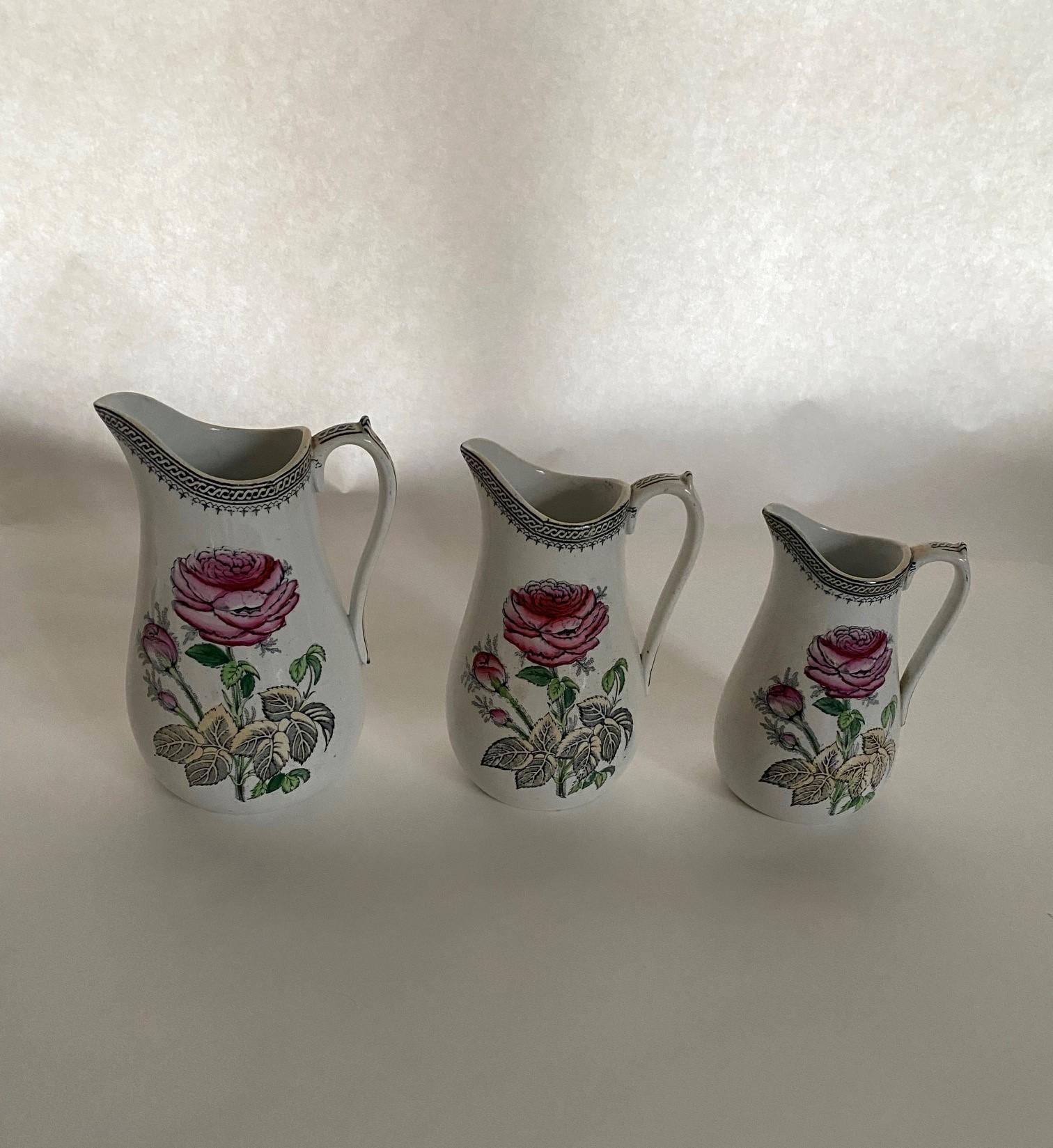 Schöner Satz von 3 Staffordshire English Rose Milchkrügen mit alter Graduierung.  Perfekt für eine Landhausküche als Dekoration oder eine schöne Ergänzung zu Ihrer nächsten besonderen Mahlzeit.  
Großer Krug - 5 1/2