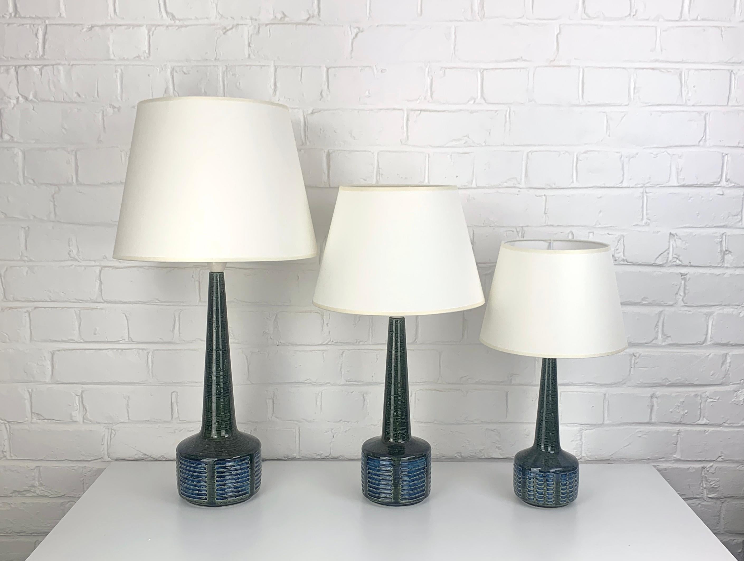Ensemble de 3 lampes de table en grès, modèles DL38, DL35 et DL34. Design/One par Per et Annelise Linnemann-Schmidt, produit par Palshus (Danemark). 

Les pieds des lampes sont recouverts d'une glaçure vert olive et d'un motif de rayures
