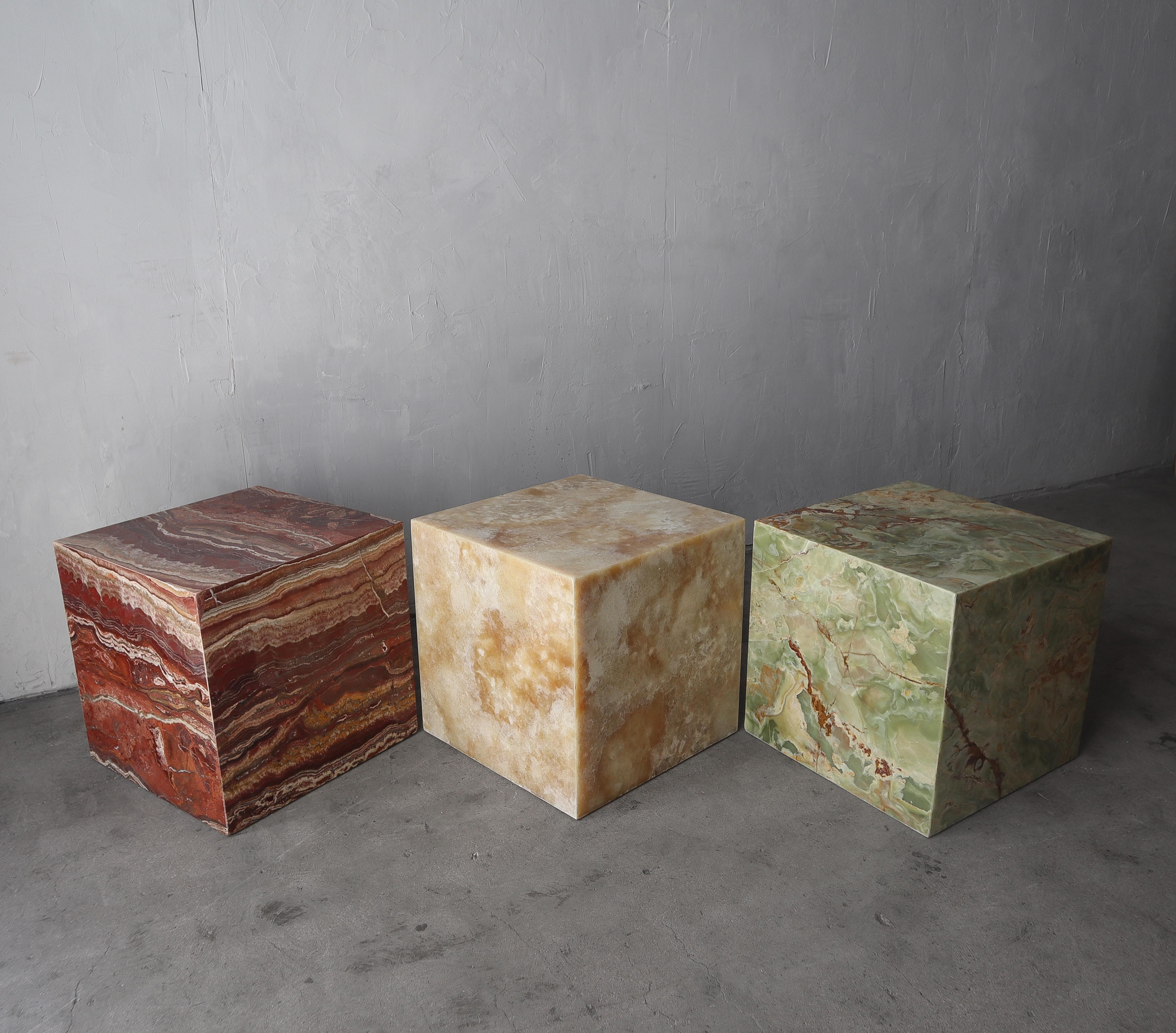 Stunning set of 3 custom made rolling Onyx cubes. They are made of the most gorgeous and heavily veined cuts of stone, 1 each, verde, honey and red onyx cube. They can be used separately or together as a show stopping collection. 

Each table
