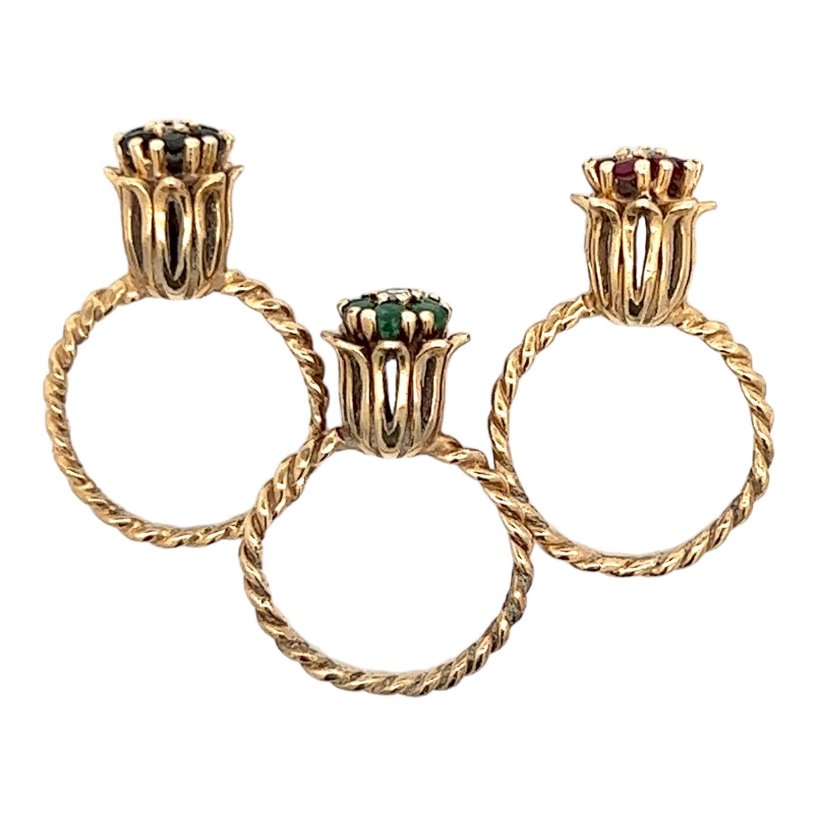 Set of three diamond, sapphire, emerald, and ruby tulip rings handcrafted in 14 karat yellow gold. The tulips feature a center round brilliant cut diamond and either ruby, emerald, or sapphire gemstones. The 3 diamonds weigh approximately .21 CTW.