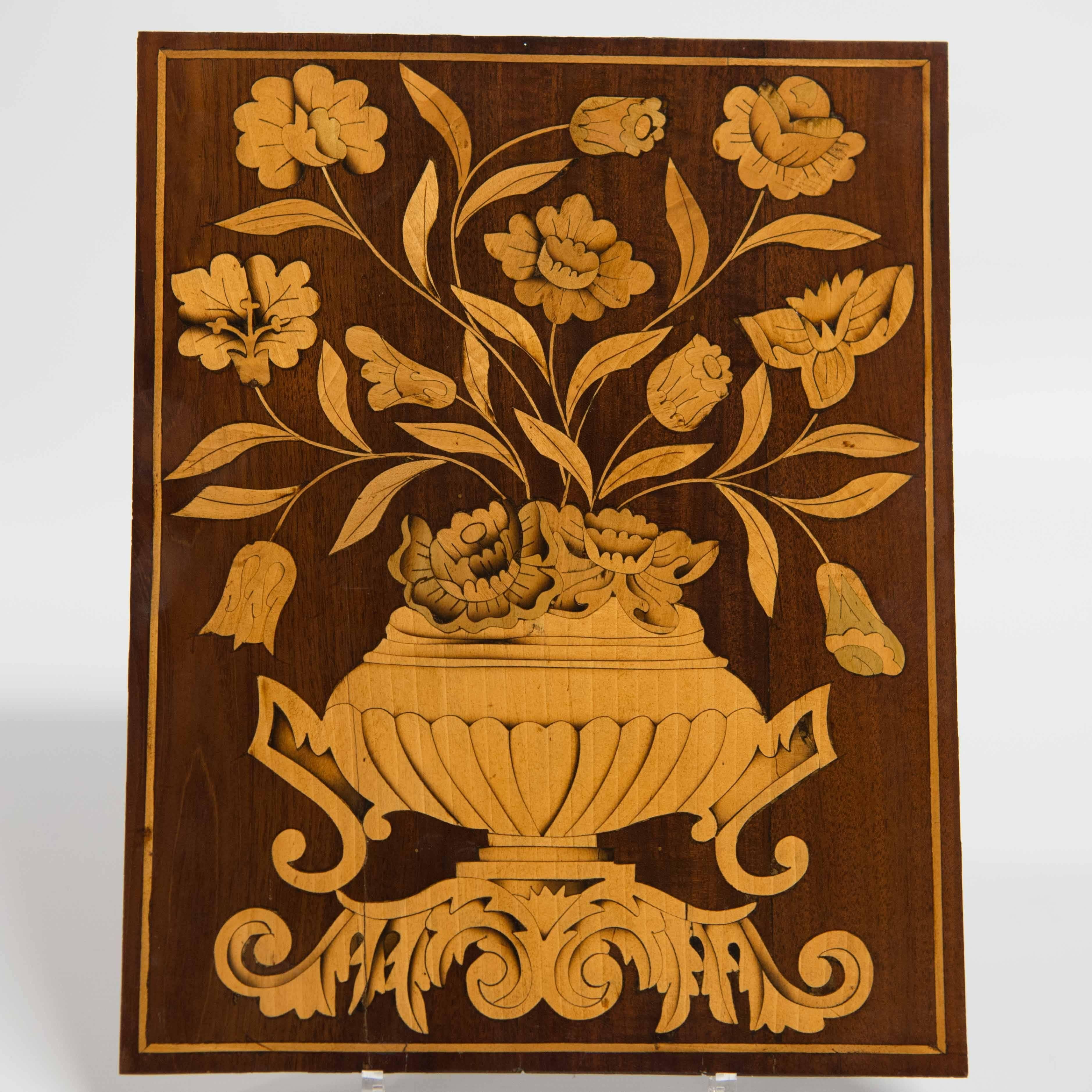 We have this set of three panels available. They are made up of a piece of oak with on top a piece of mahogany and inlaid marquetry. All displaying flowers and vases, and the middle one with birds as well. 

Size: 24.5 cm by 31 cm (2)
Size: 38.5