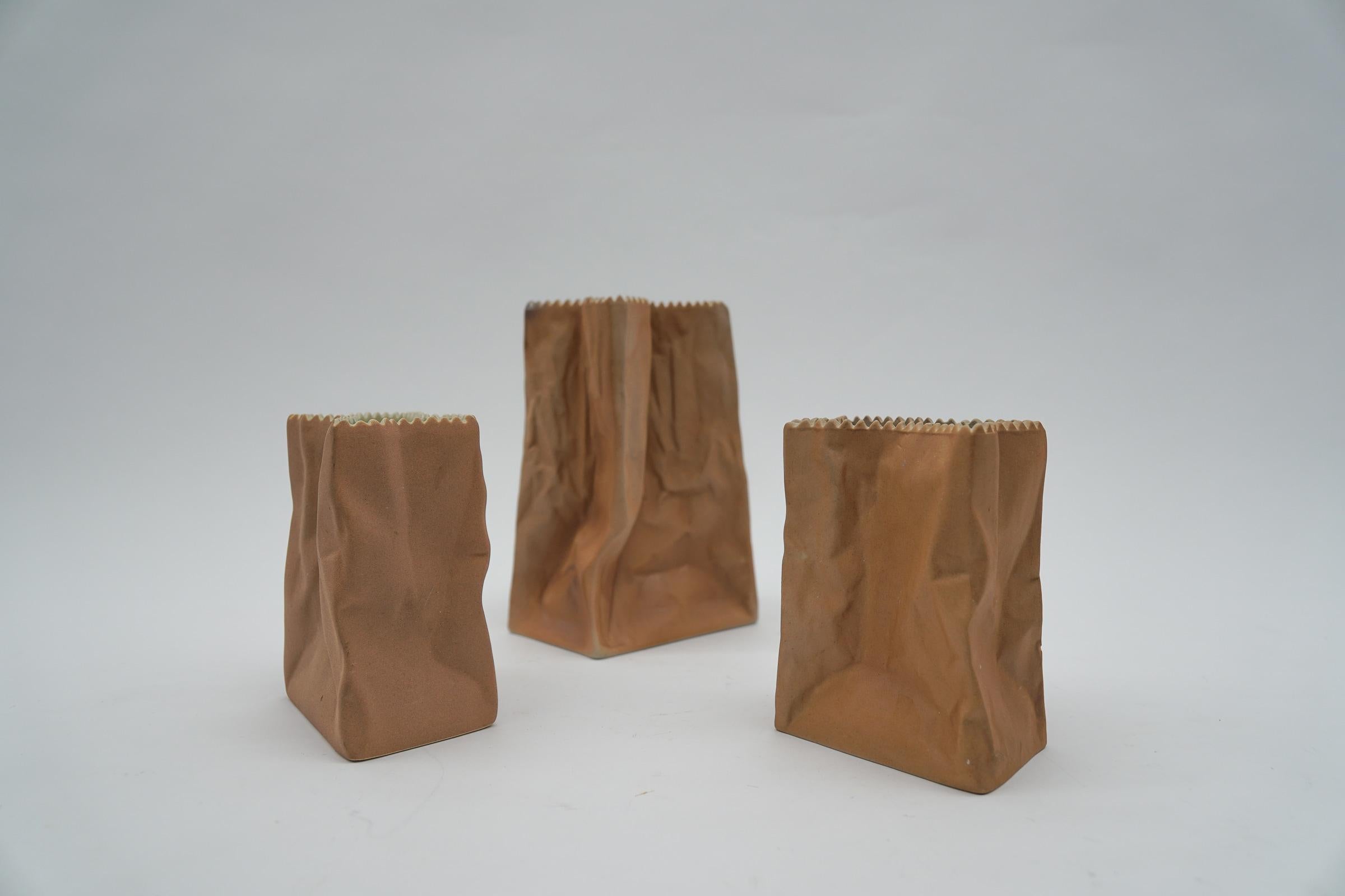 Set of three paper bag vases designed by Tapio Wirkkala and manufactured by Rosenthal, Germany, 1977. 

The large vase is 15cm high, 10cm wide and 6cm deep. 
The small vase is 10cm high, 8cm wide and 5cm deep.

This vases are made of porcelain