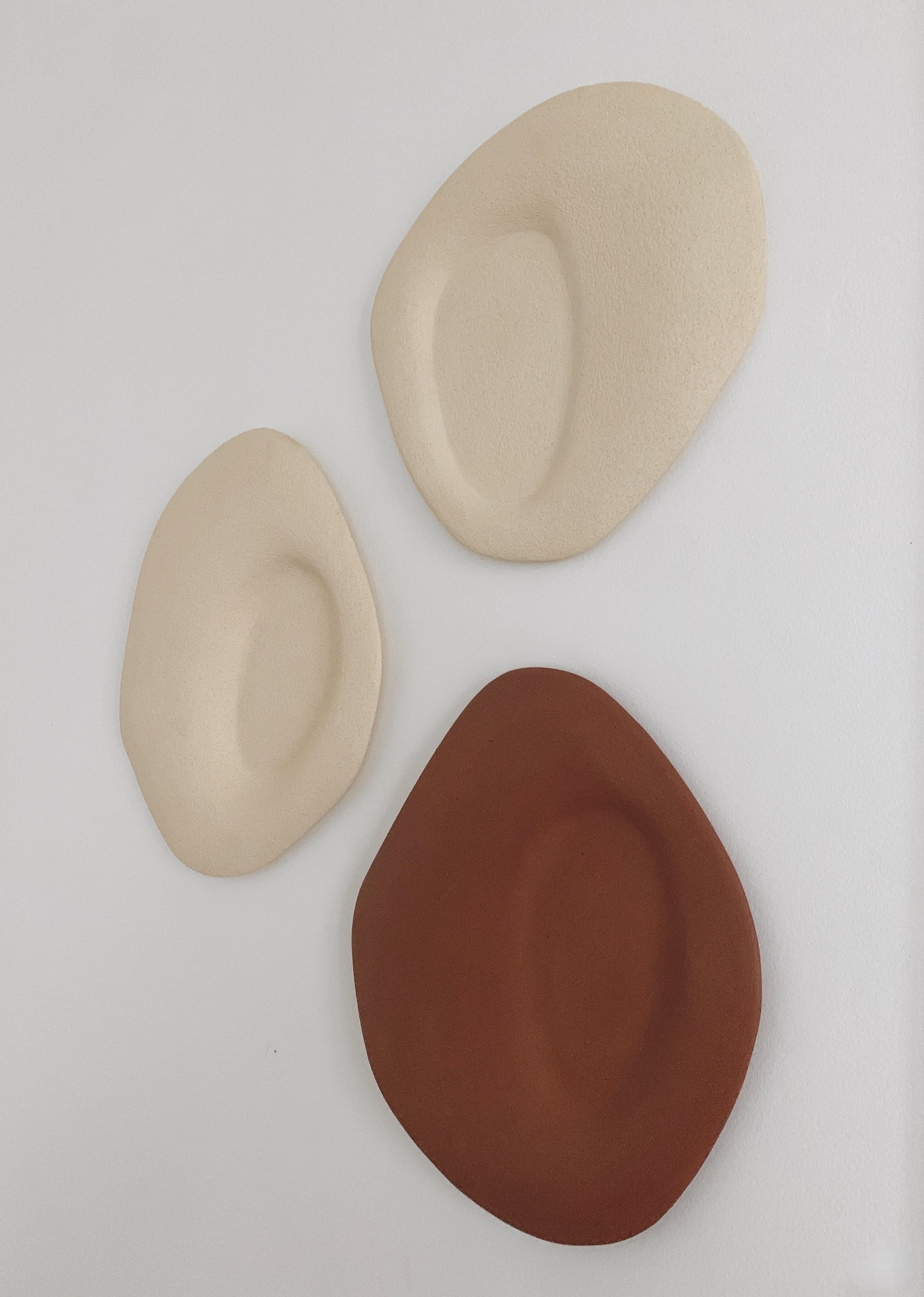 Set di 3 sculture da parete particules elémentaires di Léontine Furcy.
Pezzi unici.
Materiali: Pietra arenaria bianca chamotte grezza e retro in ossido rosso chamotte grezzo.
Dimensioni: 
Rosso: L 27,5 x H 30,5.
Bianco: L 28 x H 28 cm.
Bianco: