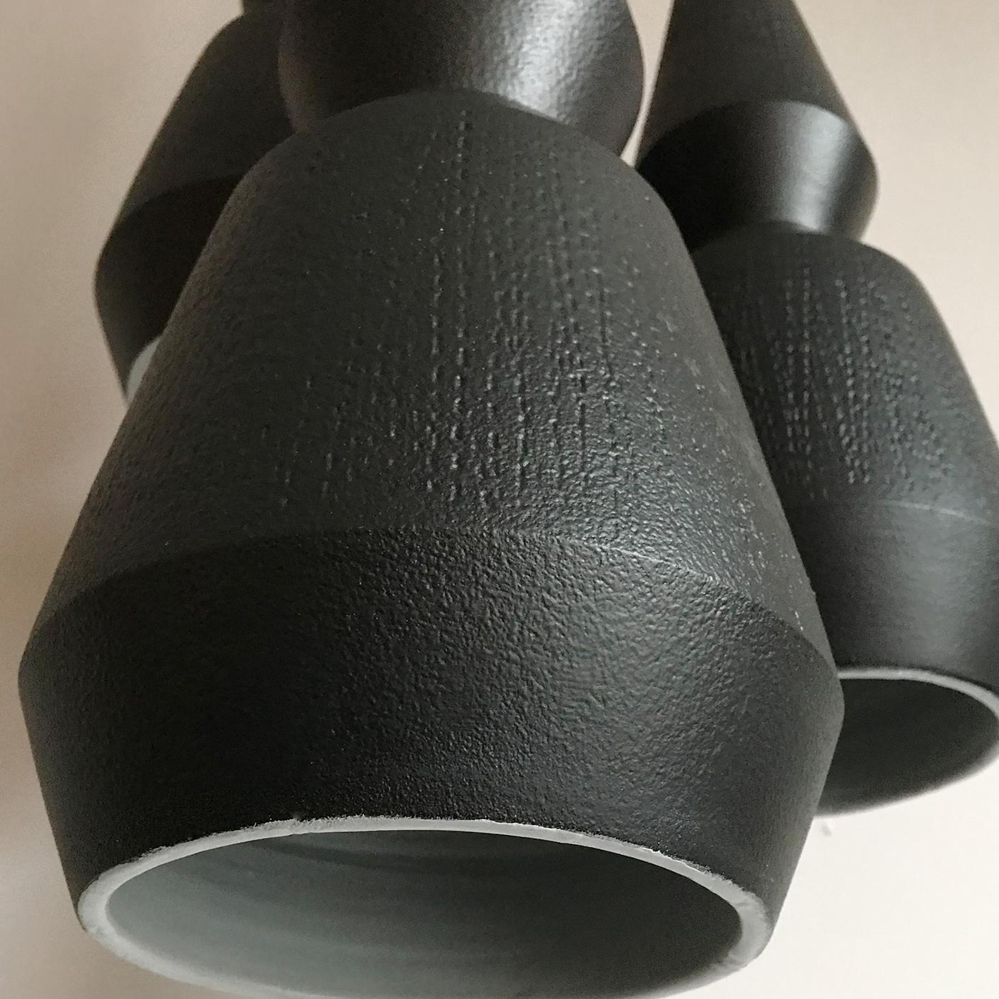 Worked on a lathe by hand, this set of three pendant lamps is a superb example of traditional craftsmanship in an authentically modern design. Each pendant is a sculptural work of art made of ceramic with a matte black-lacquered finish, enriched