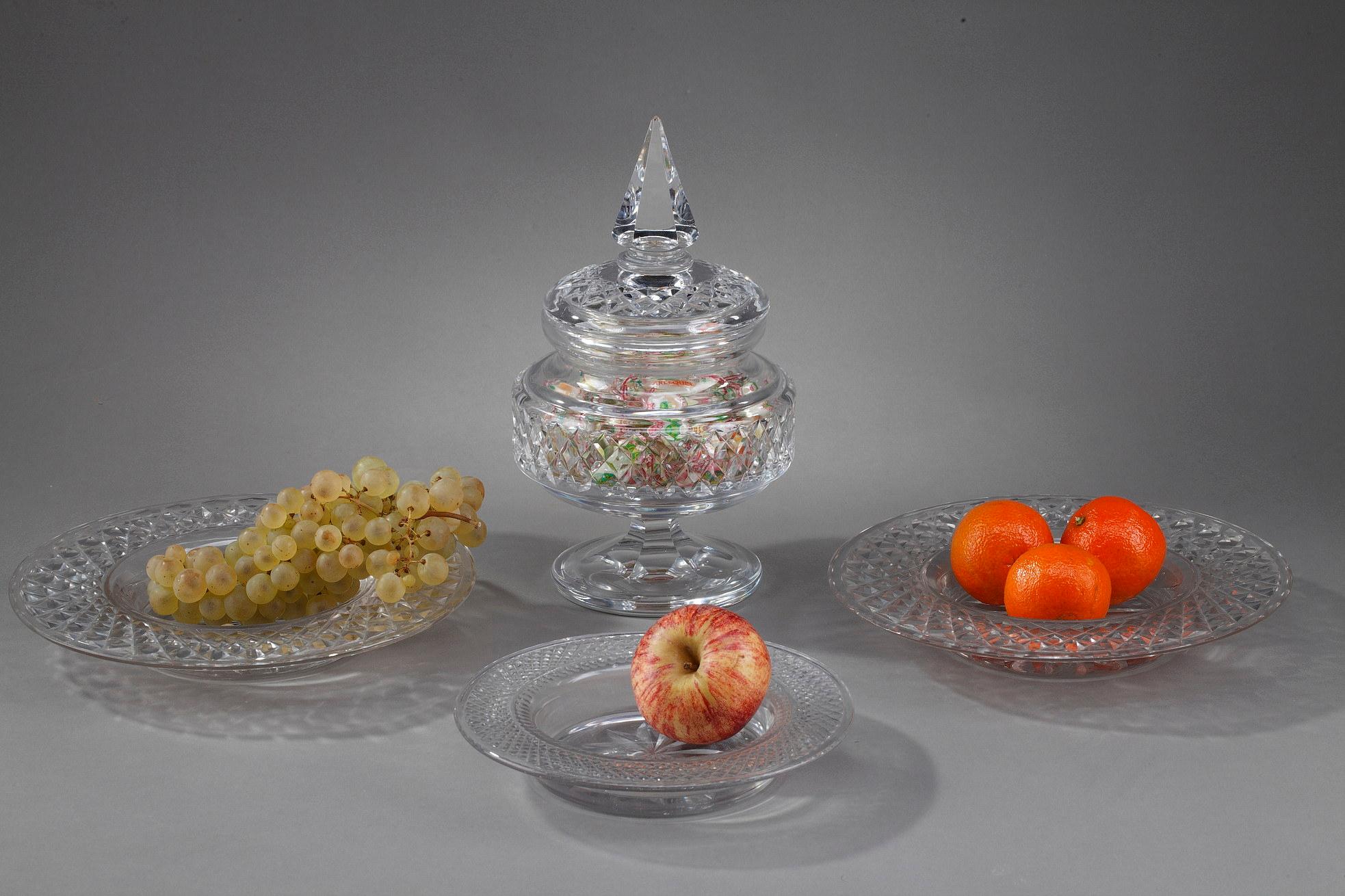 One candy box and three plates in Baccarat quality crystal finely cut, from the early 20th century. The plates are decorated with guilloche motifs on the wings while the underside is cut in a rosette. The bonboniere, with a similar decoration has a