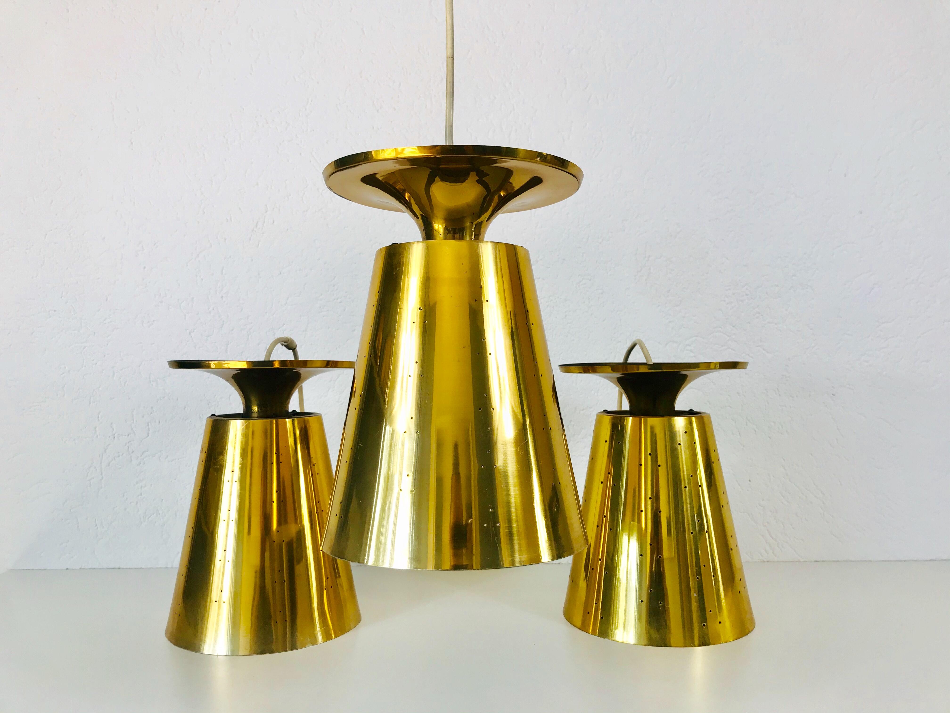 Set of three very rare pendant lamps attributed to Paavo Tynell, made in Finland in the 1950s. The lighting is made of full of brass. It has many small holes which are creating beautiful light. The lighting requires one E27 light bulb.

Measures: