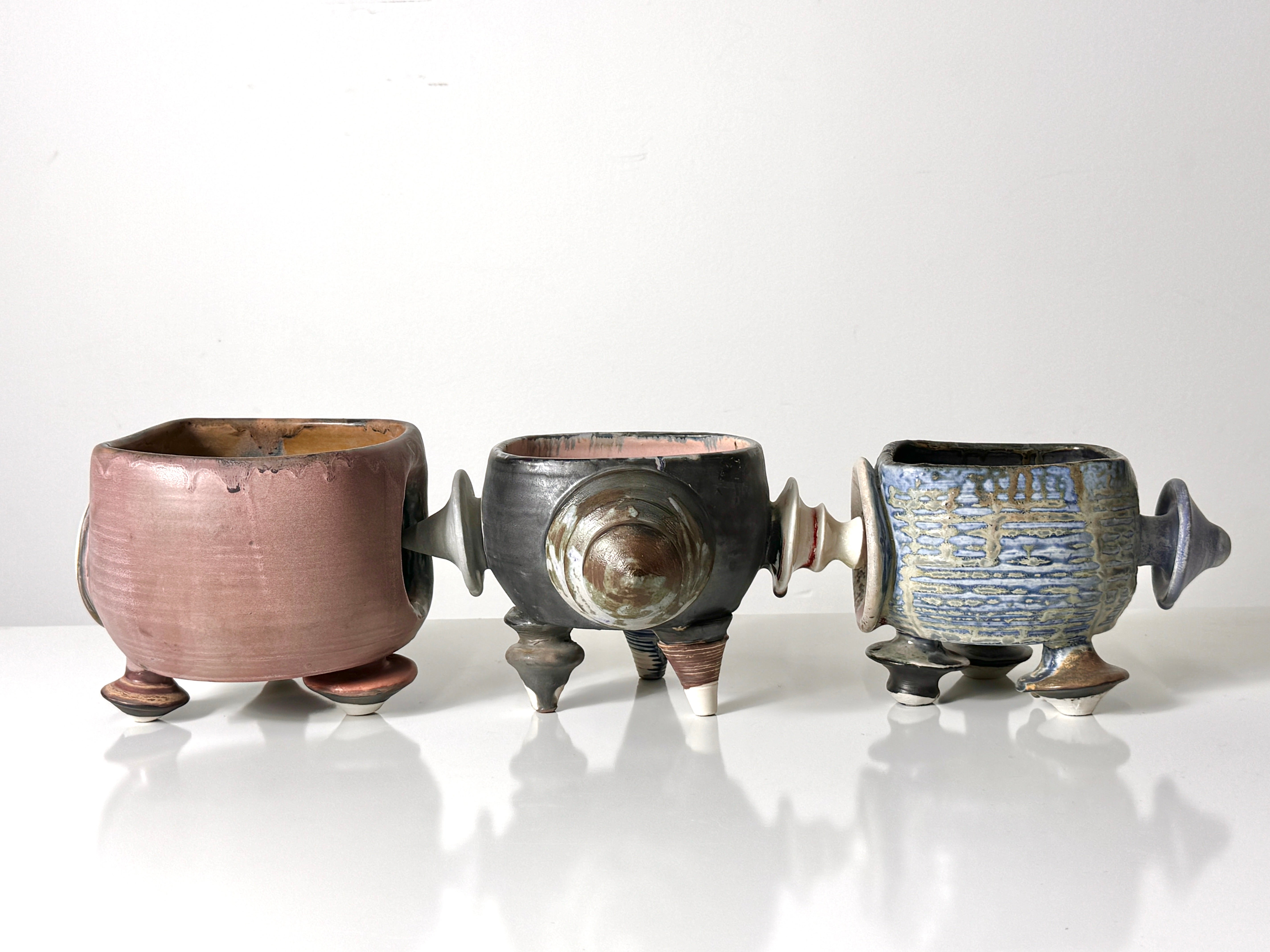 A grouping of three modular ceramic bowl sculptures by Michigan artist Kaiser Suidan 1992

Unique footed bowls in a conjoined puzzle like configuration with various designs and glazes
A rare example of Suidan's earlier work 
Signed and dated to