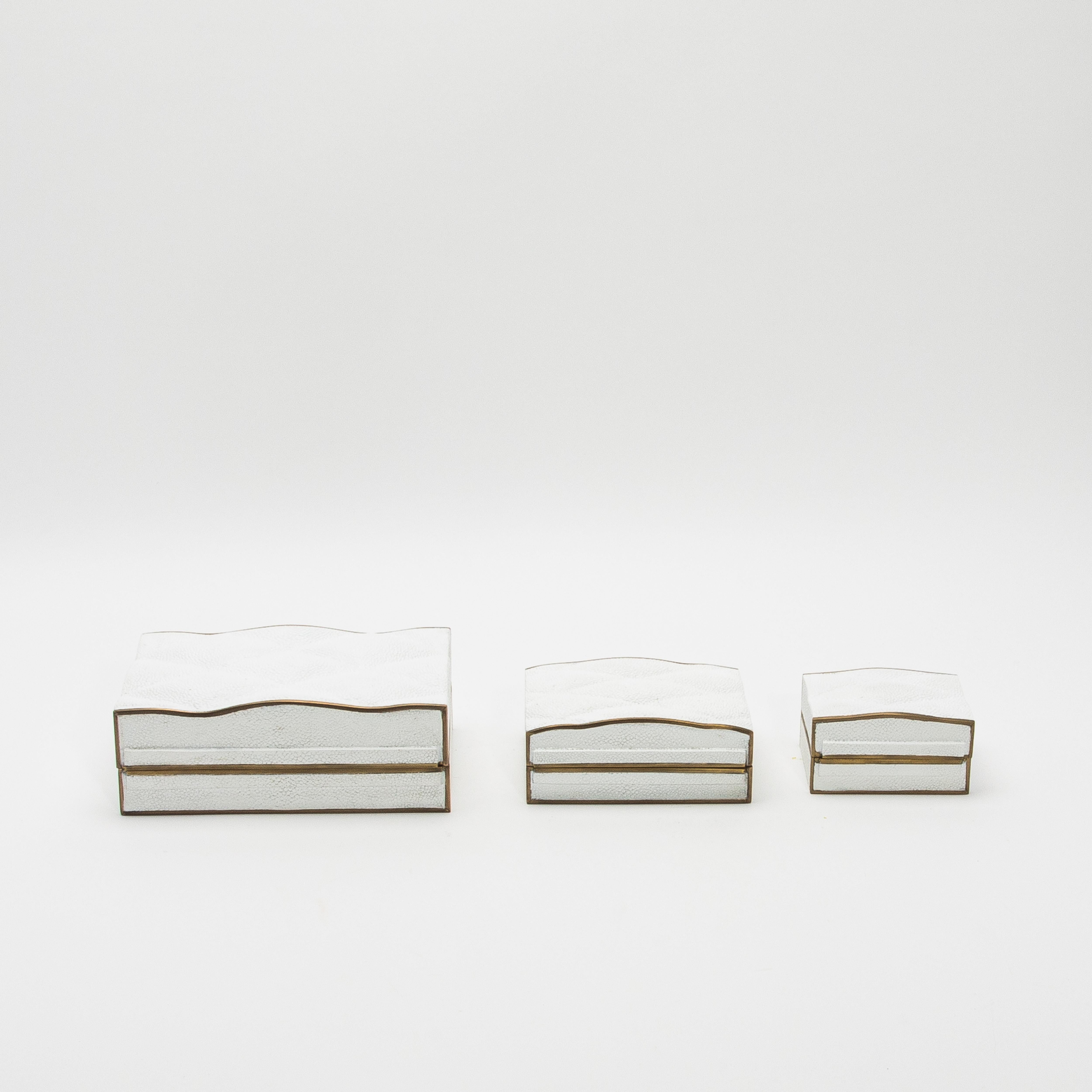 La colección de cajas Coco de Kifu Paris ejemplifica el lujo a través de su intrincado diseño y su meticulosa artesanía. Este conjunto de tres cajas acolchadas en piel de zapa negra, enmarcadas con un borde de latón patinado en bronce, irradia