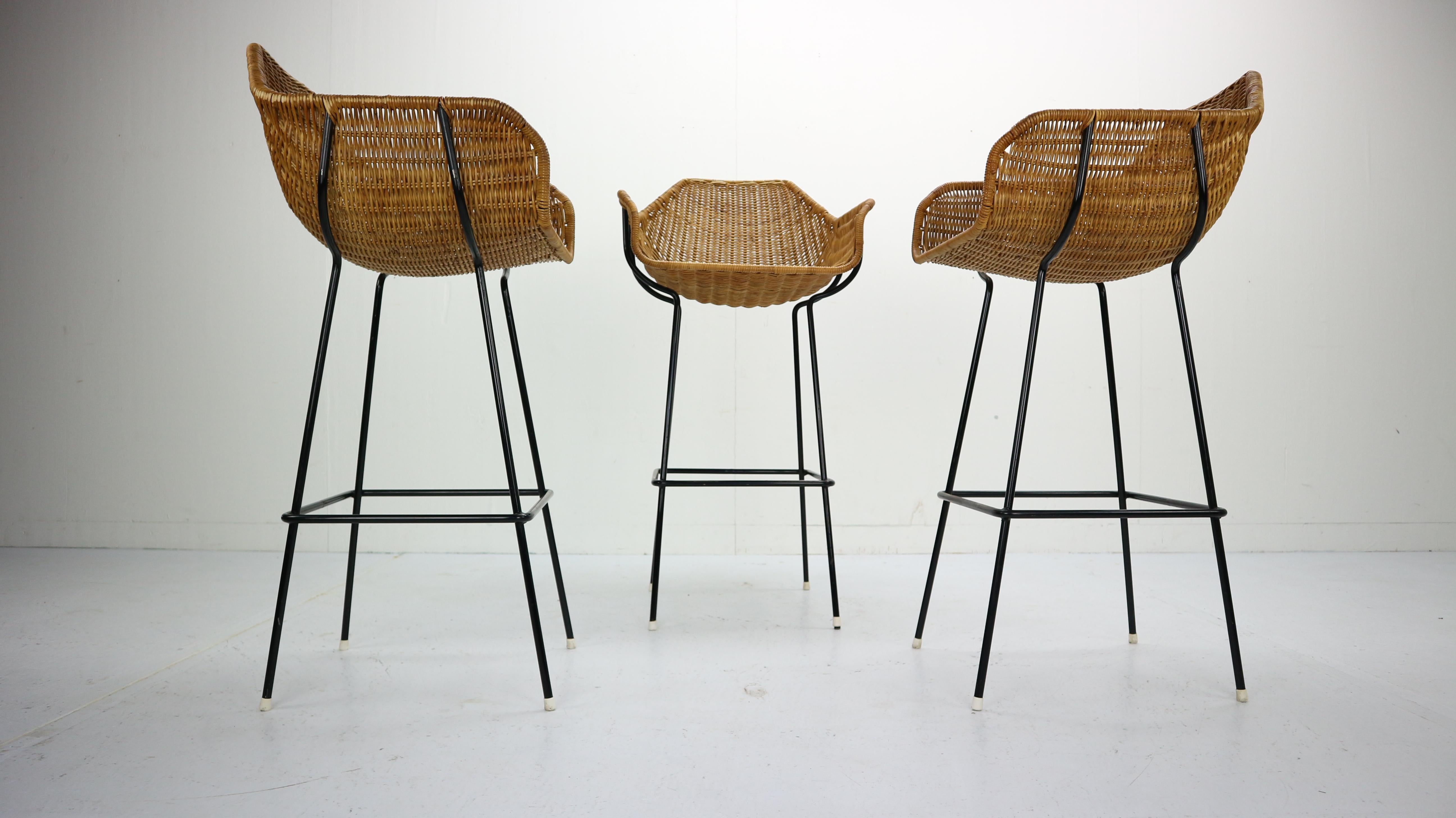 Set of 3 rare bar stools design by Dirk Van Sliedregt and manufactured in the Netherlands circa 1960s by Rohe Noordwolde.

Gorgeous original set within elegantly woven rattan bucket seats and black metal frames. Original condition.