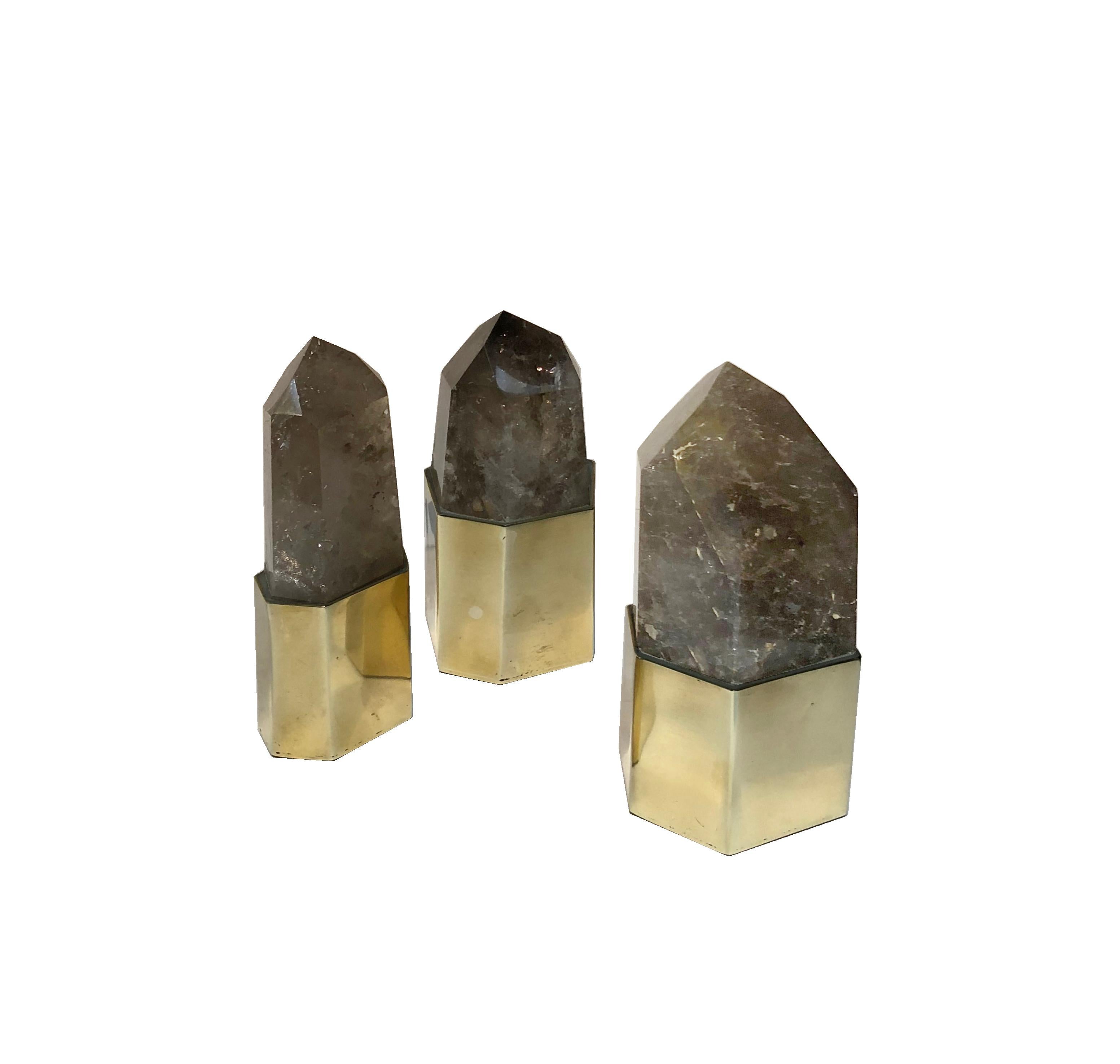 Stunning set of 3 smoked quartz setted on a geometrical multifaceted natural brass bezels. 
An eye-catching decorative object and a statement timeless piece suitable for every space: picture it above a stack of coffee table books or close to a