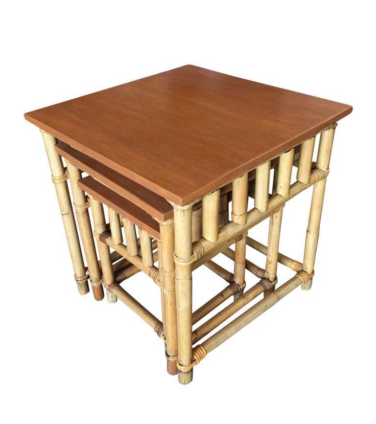 A wonderful set of 3 Paul T. Frankl inspired Rattan nesting tables with inset mahogany tabletops. The Rattan used for these nesting tables was imported from the Philippines and assembled in the United States, as is typical of high-end Rattan of the