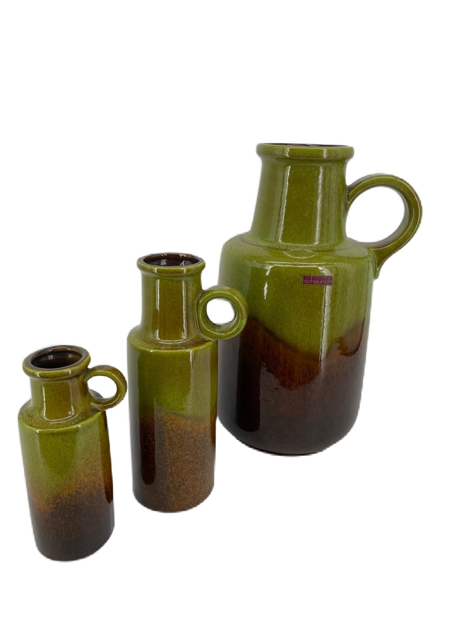 Lot de 3 vases à lave grasse Scheurich rétro vintage de l'Allemagne de l'Ouest / vases à oreilles. Couleur vert-brun. Modèle n° 408-40, 401-28, 401-20. 
Mesures : L. 5.12 in ; H. 11.02 in ; P. 5.12 in ; 
W. 13 cm ; H. 28 cm ; D. 13 cm ; 
W. 3.94