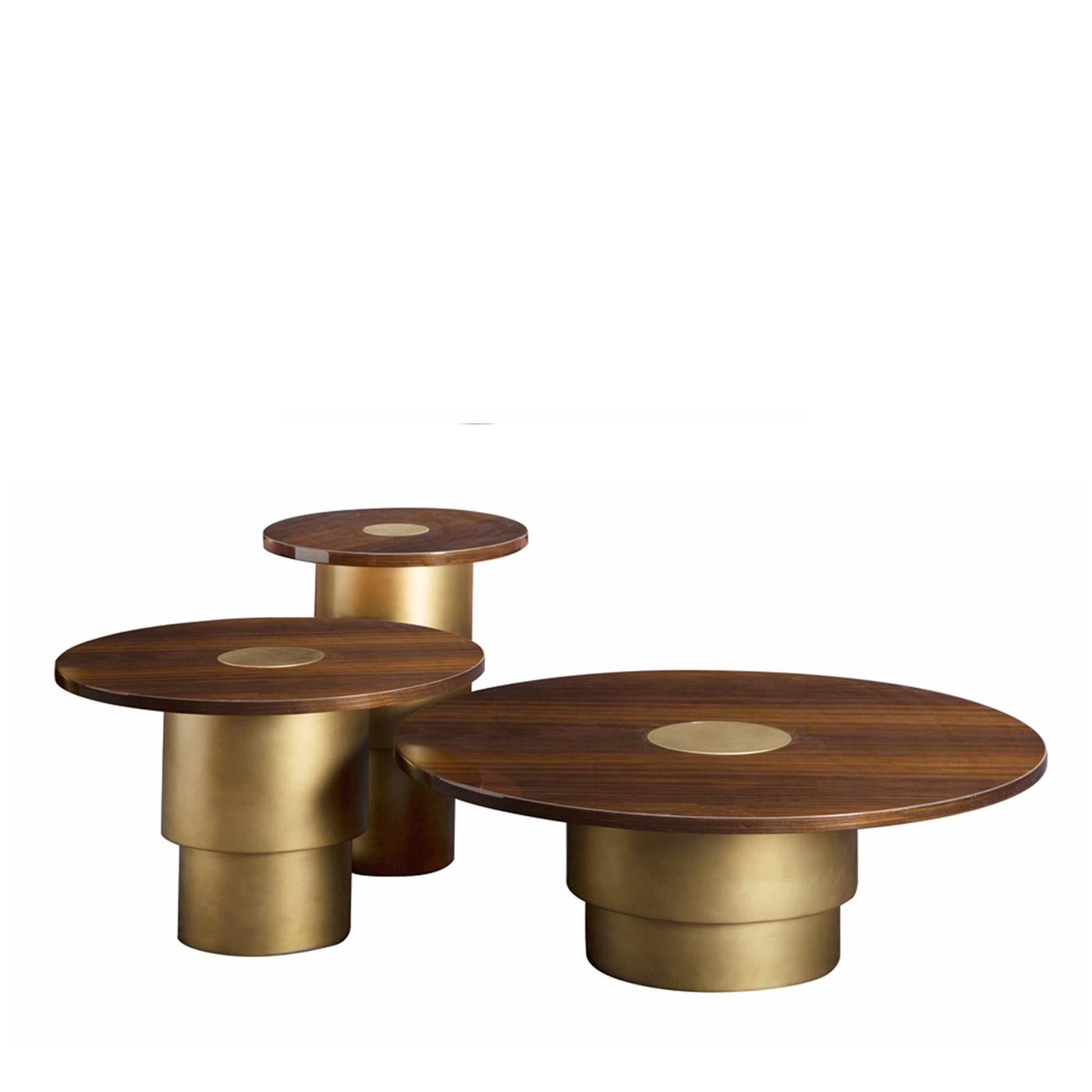 With a turned solid wood base finished in a burnished brass effect, the set of 3 Rondò coffee tables offers elements of warmth and functionality to your home. The plywood top features a dark walnut veneer and a unique central circle finished in