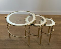Set of 3 round brass nesting tables with glass tops surrounded with silver rims