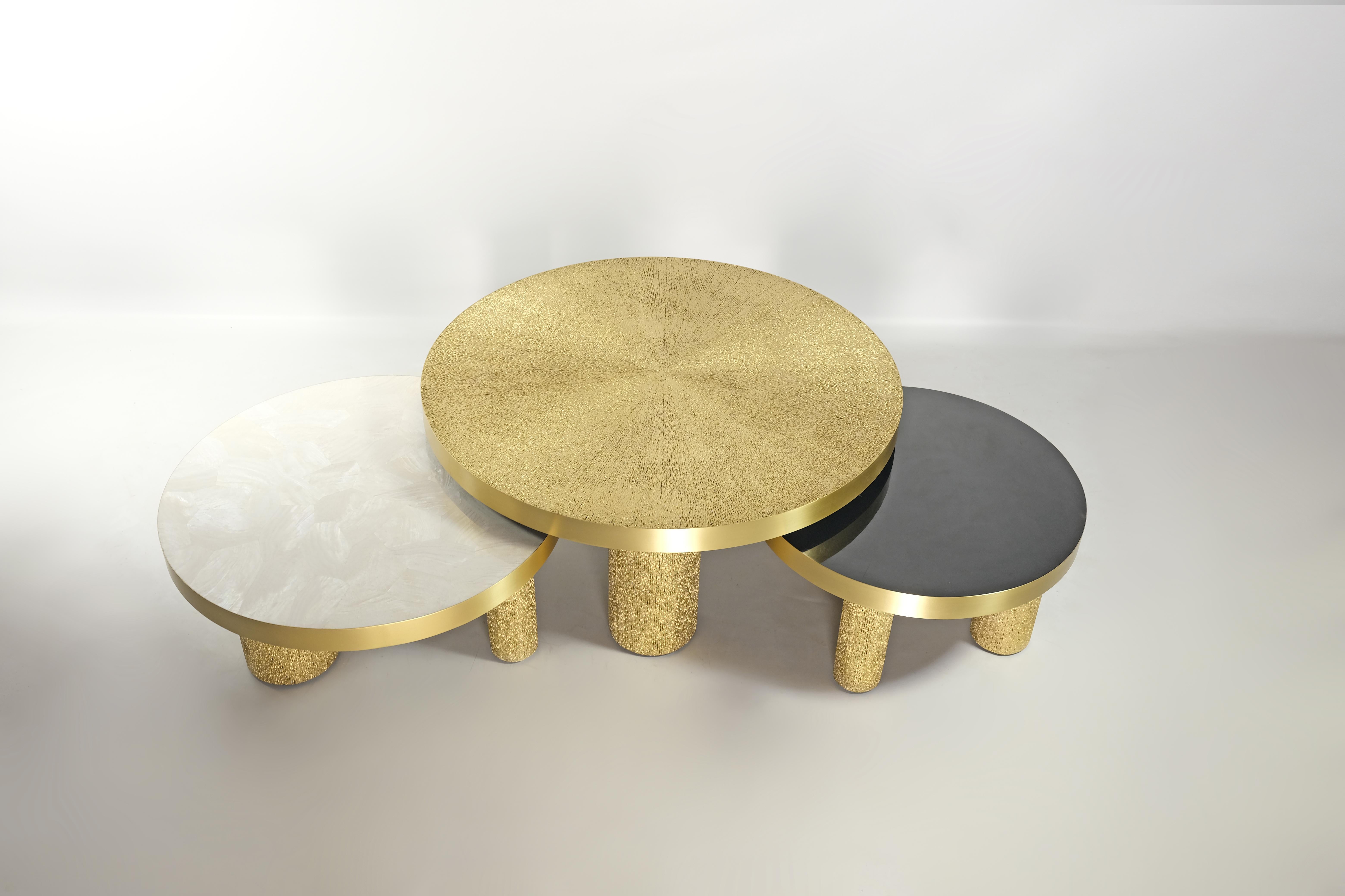 This set of 3 round coffee tables is made of various inlaid materials.
These modular tables can be setted up following your wishes.
The center piece is covered with a gilded natural fiber marquetry, the side tables are inlaid with black and white