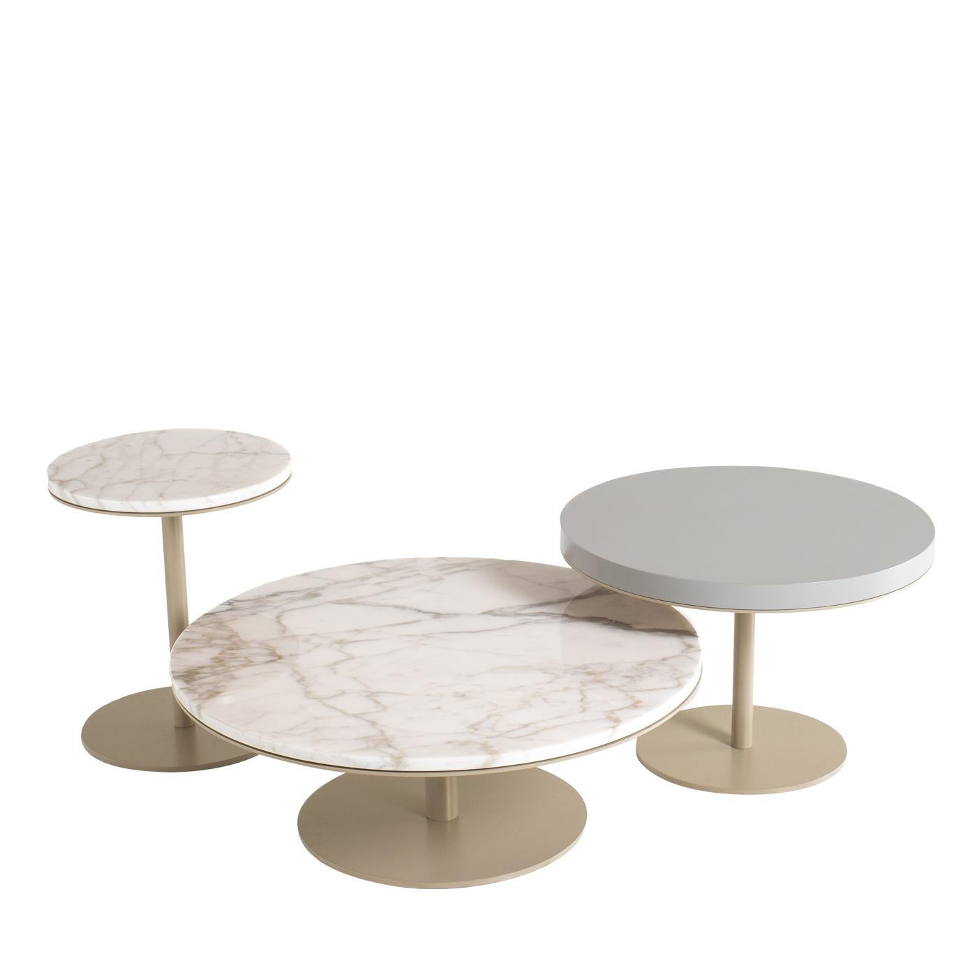 Create an original space to serve drinks and snacks in a contemporary lounge area with this set of three round serving tables. Fully customizable, the tables shown here feature a matte gold base, two marble tops and one lacquered wood top. The