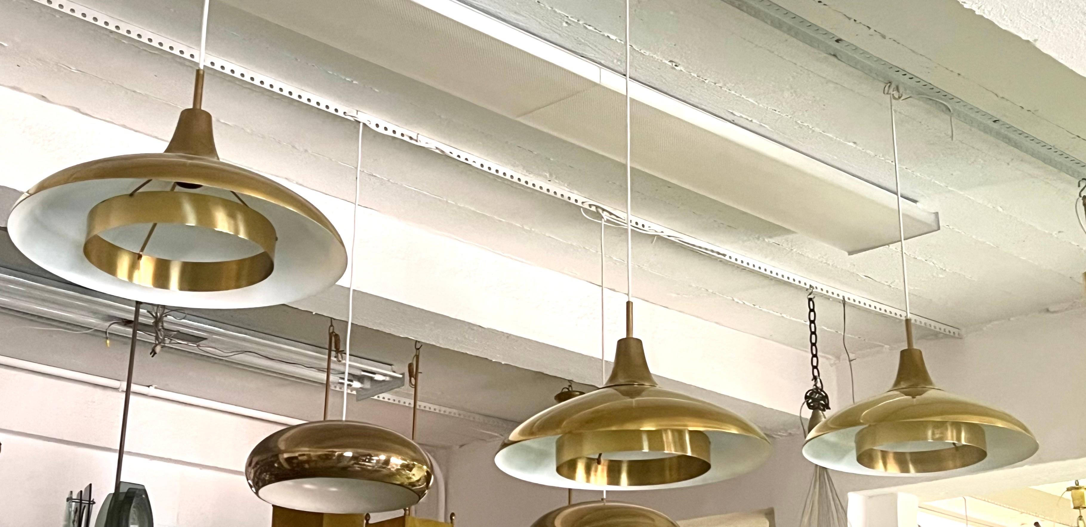 Elegant, intemporel et rare ensemble de 3 pendentifs en laiton massif de Borens, Suède, datant de 1960. Les luminaires illustrent une perspective minimaliste que l'on retrouve dans les arts décoratifs danois, suédois et finlandais, où la fonction et