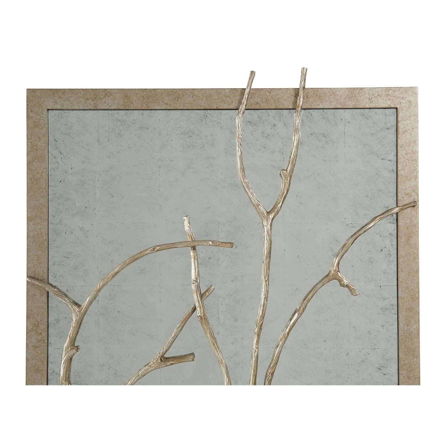 A set of three silvered metal and silvered wood framed wall panels, each rectangular frame with a cast branch overlaid on an antiqued hand leafed mirror back.

Dimensions: 26
