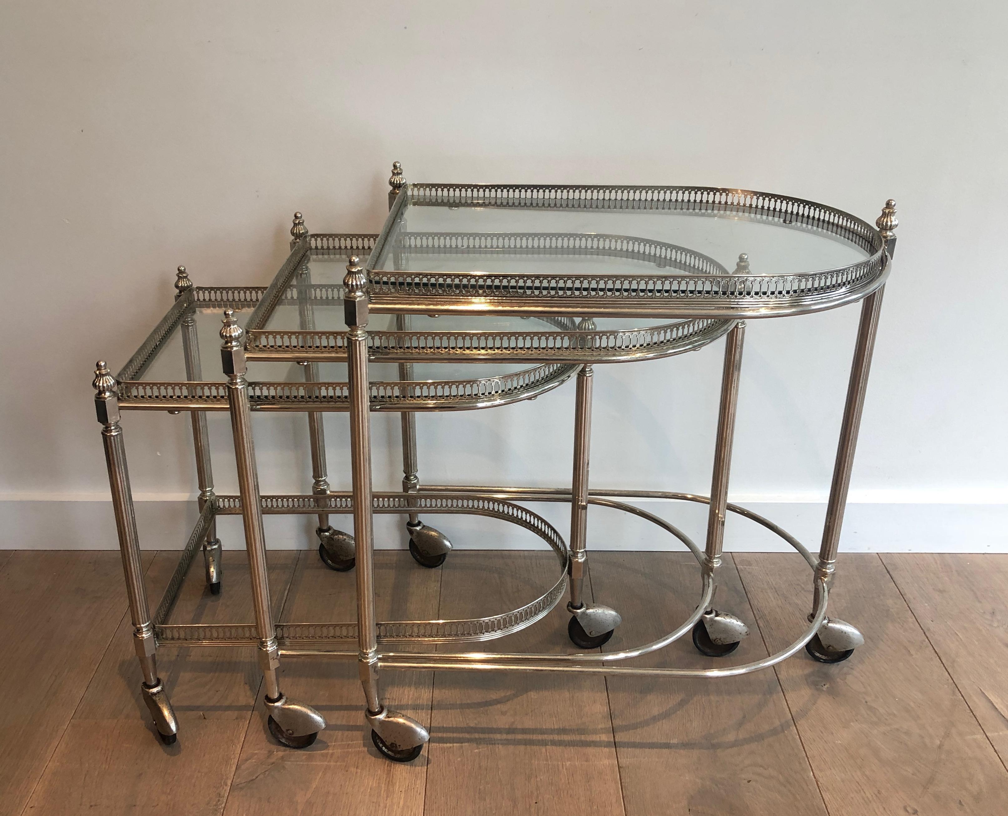 This nice set of 3 nesting drinks trolleys with removable trays is made of silvered on brass. This is a French work by Maison Bagués. Circa 1940