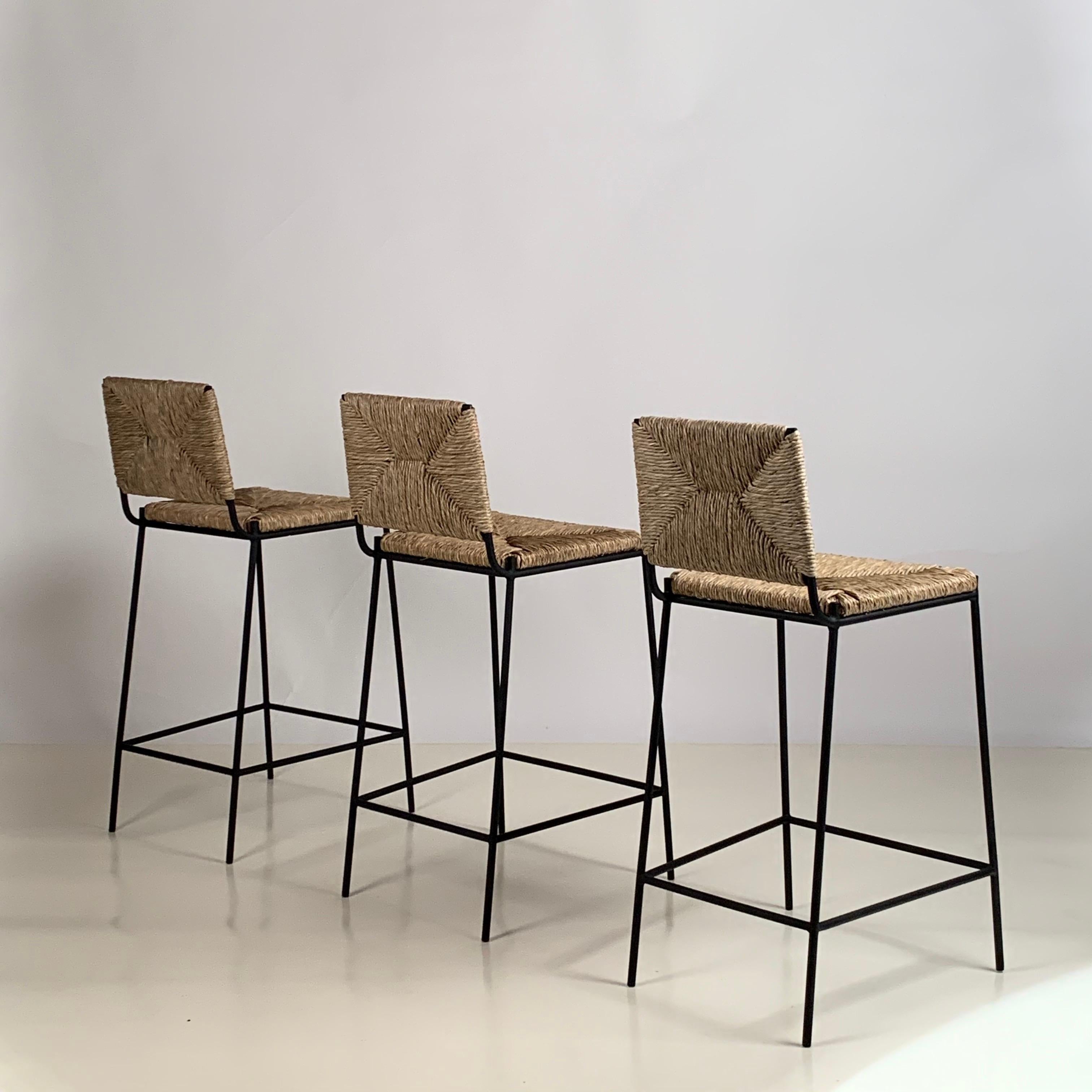 Set of 3 slender 'Campagne' counter stools by Design Frères.

Comfortable, with a minimal footprint.

Extra support under the rush seat.

Feet pads to protect flooring.